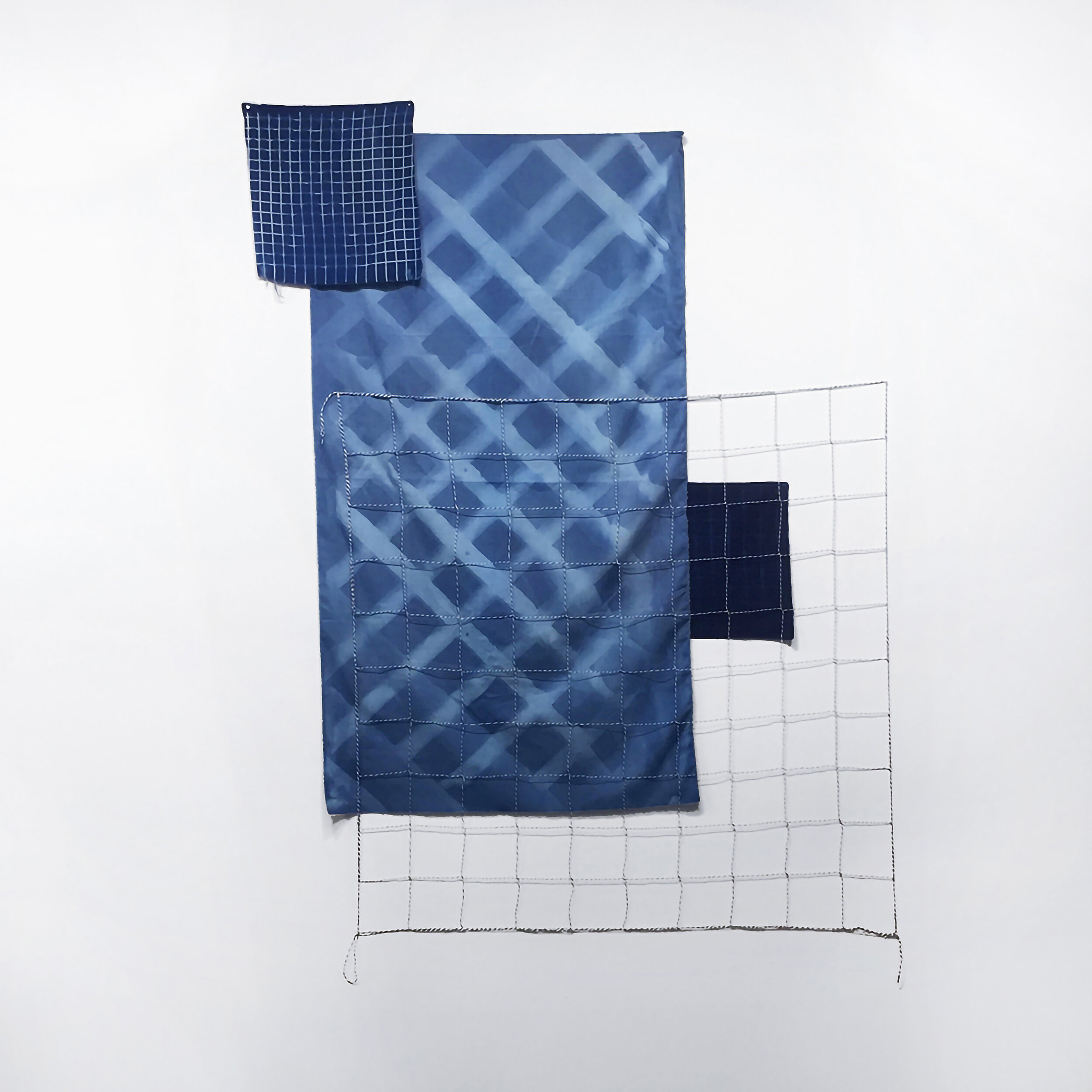 untitled (assemblage 002). 2018. cyanotype on found fabric, bakers twine, and nails. 57 x 53 x 1/2 inches
