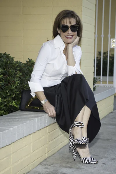 Anne Fontaine Blouse , CAbi Belt, Donna Karan Skirt, similar here , Tom Ford Clutch, similar here , Tom Ford Shoes, on sale here , Robin Terman Necklace , Karen Walker Sunglasses , Essie Nail Polish “For the Twill of It” .