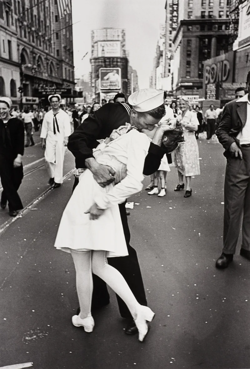 Victory Over Japan (V-J) Day in Times Square , a photograph by Alfred Eisenstaedt, was published in Life in 1945 with the caption, In New York's Times Square a white-clad girl clutches her purse and skirt as an uninhibited sailor plants his lips squarely on hers. Read the story behind this infamous and most copied photograph here.
