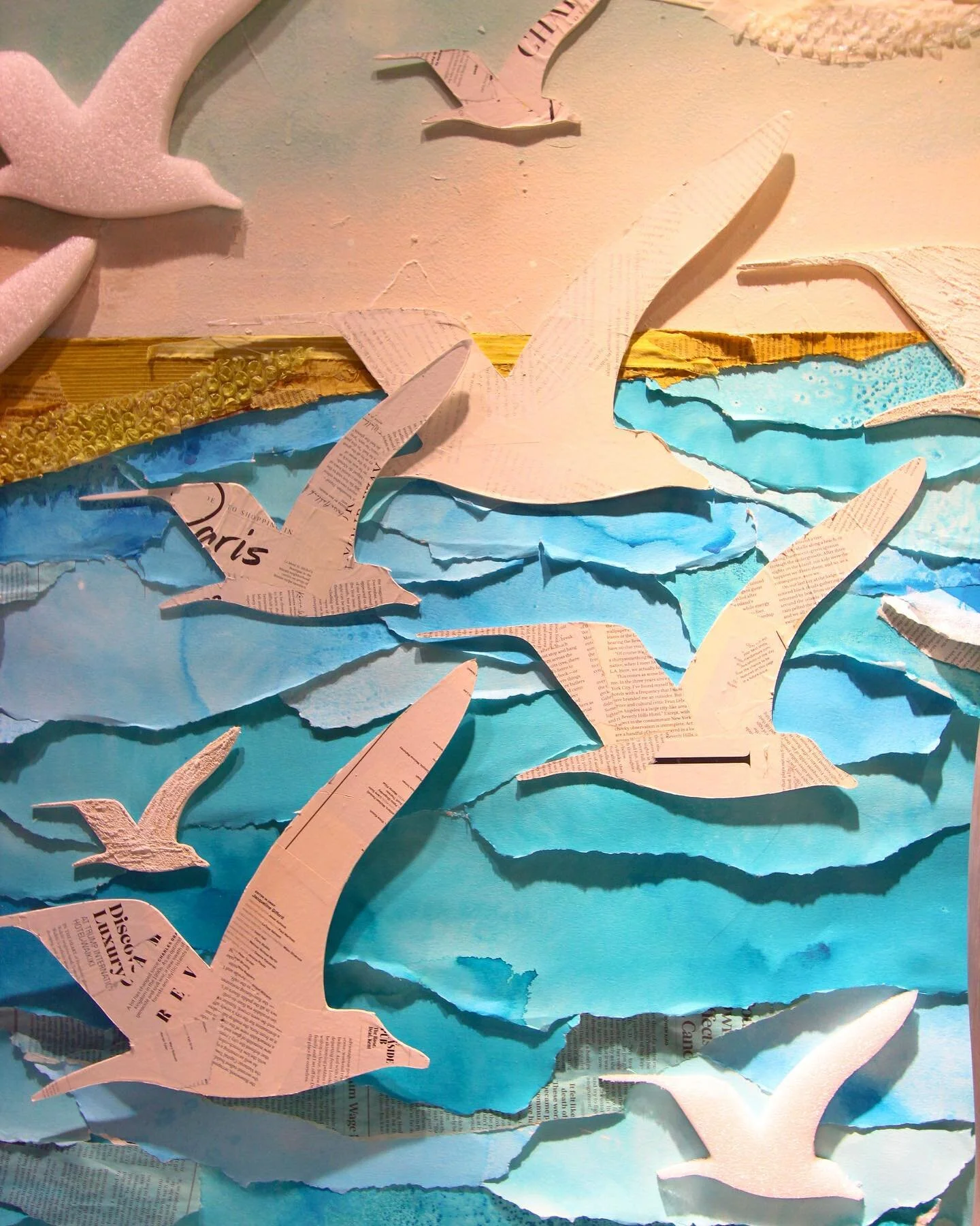 Another close-up shot of the &ldquo;Water&rsquo;s Edge&rdquo; window installation. 🌊 This section of the display highlights the mixed-media birds that are featured throughout the window. The 2D birds are covered with recycled magazine pages, packing