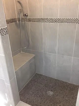 Plum Co removed the old tub and shower with three handle tub & shower valve to transform the space into a modern shower with a new Delta shower valve equipped with diverter for shower head & handheld sprayer.