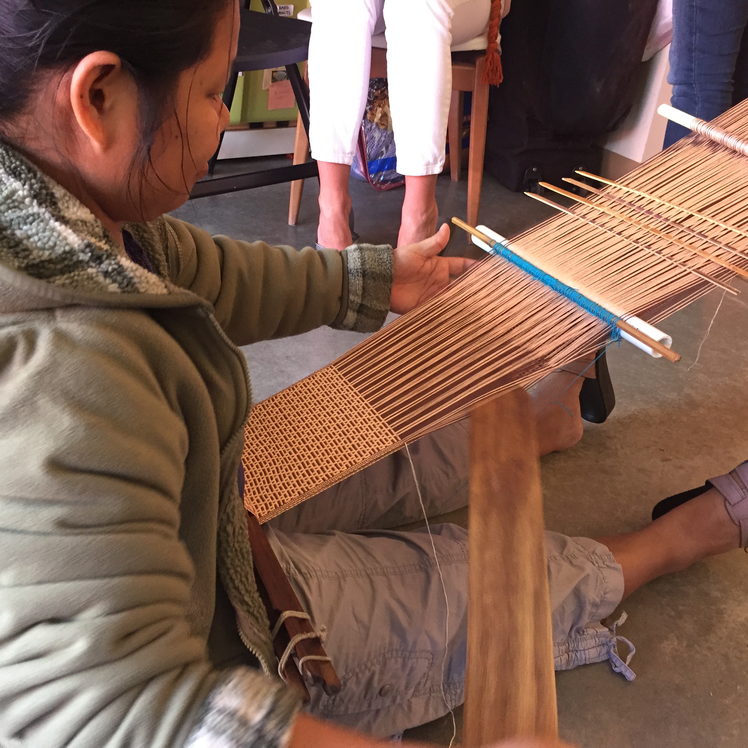 Mu Mu using the back strap loom that her grandmother taught her how to use when she was 10 years old in Burma.