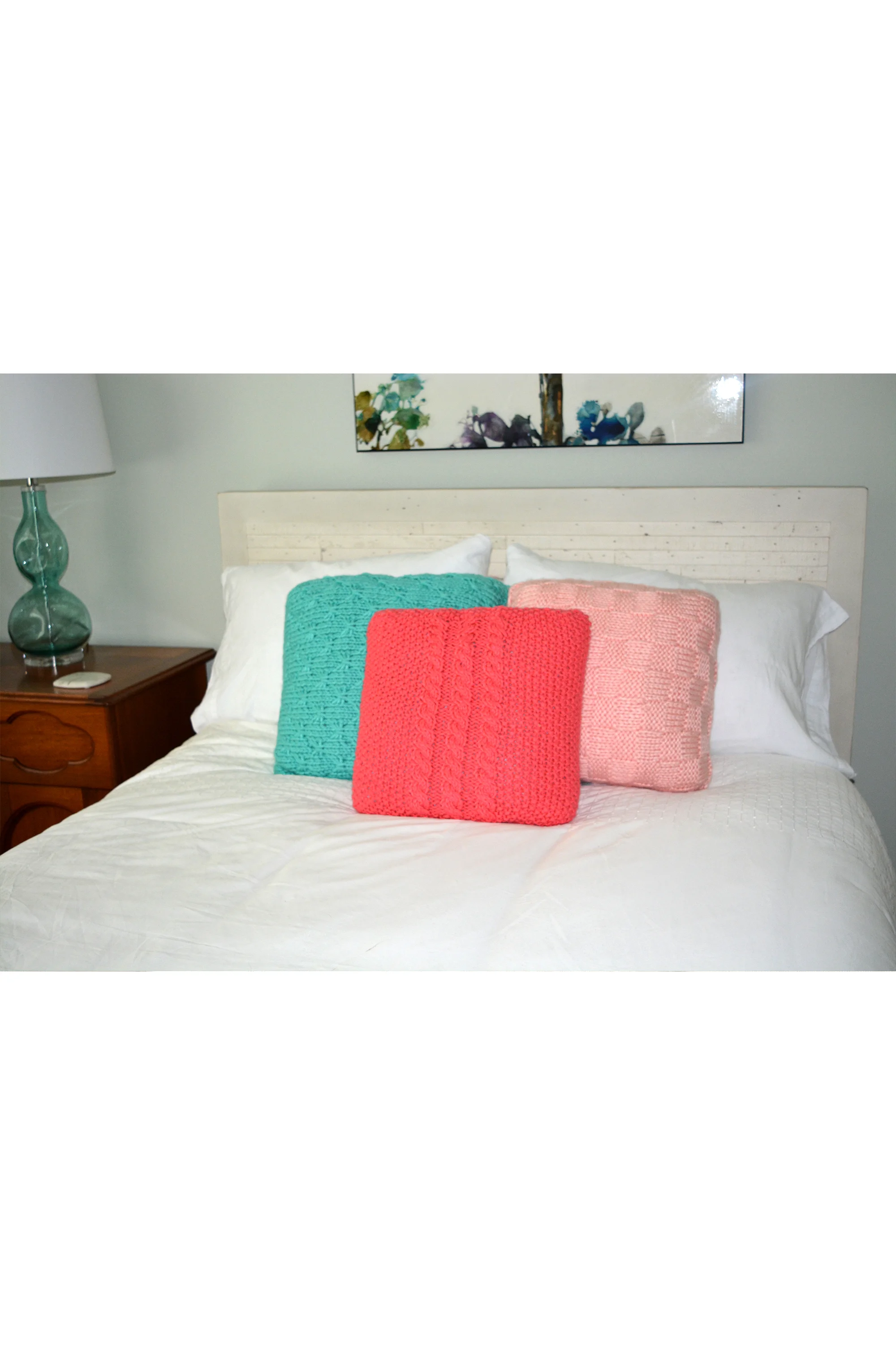 pink and blue knit pillows on bed.jpg
