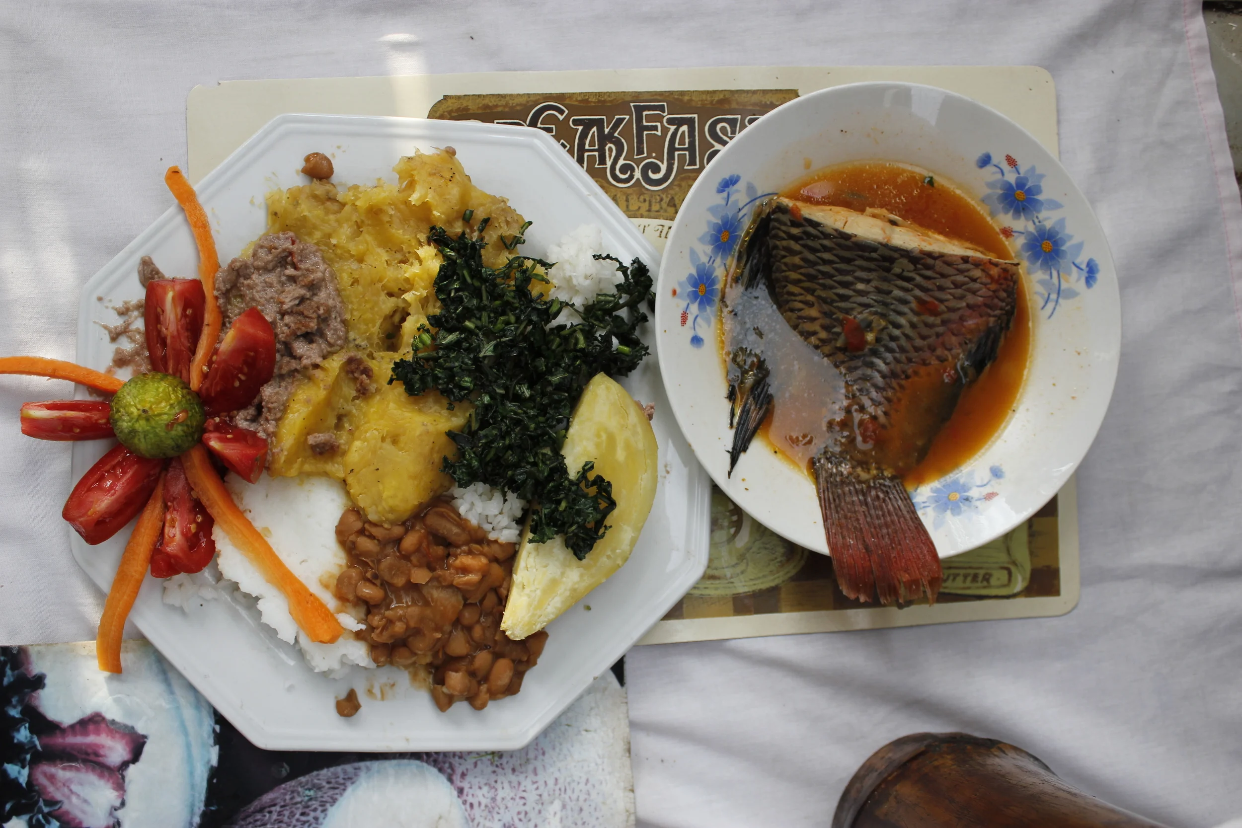 the full combo: "all foods"( posho, beans, matooke, rice, sweet potato) , greens, salad, g-nut and a delicious mputa (nile perch) tail. ( photo : Moses Bwayo)