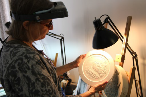 Artista de la casa de mondeda EE.UU ,Phebe Hemphill, Medallic Escultor. Febe esta graduada en la Academia de Pensilvania de Bellas Artes; también trabajó como escultor en Franklin Mint durante 15 años. Aquí, Febe inspecciona un modelo de yeso.