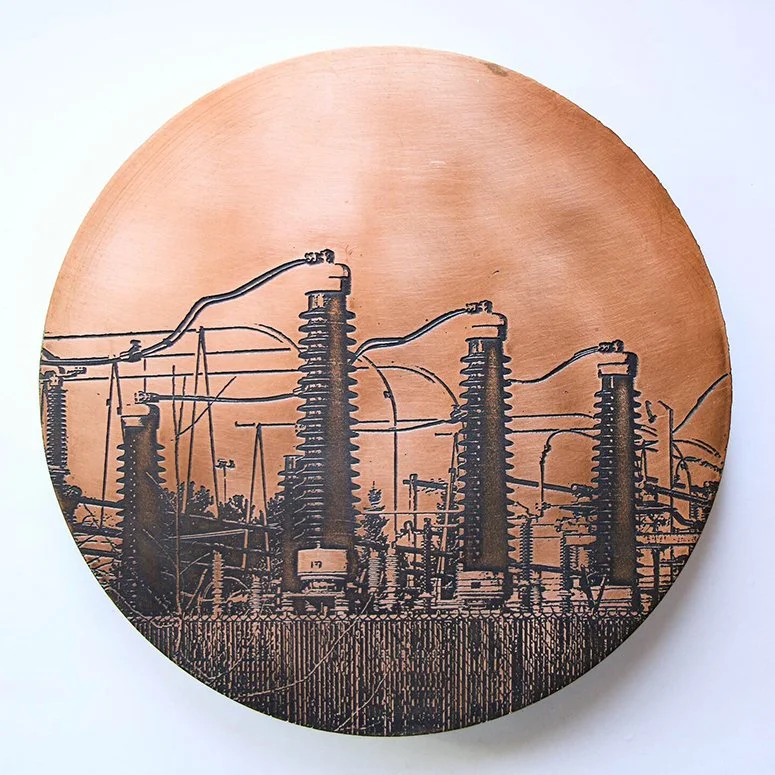 Round copper plaque by Dana Reed with etched image of four conical, ribbed electric pylons.