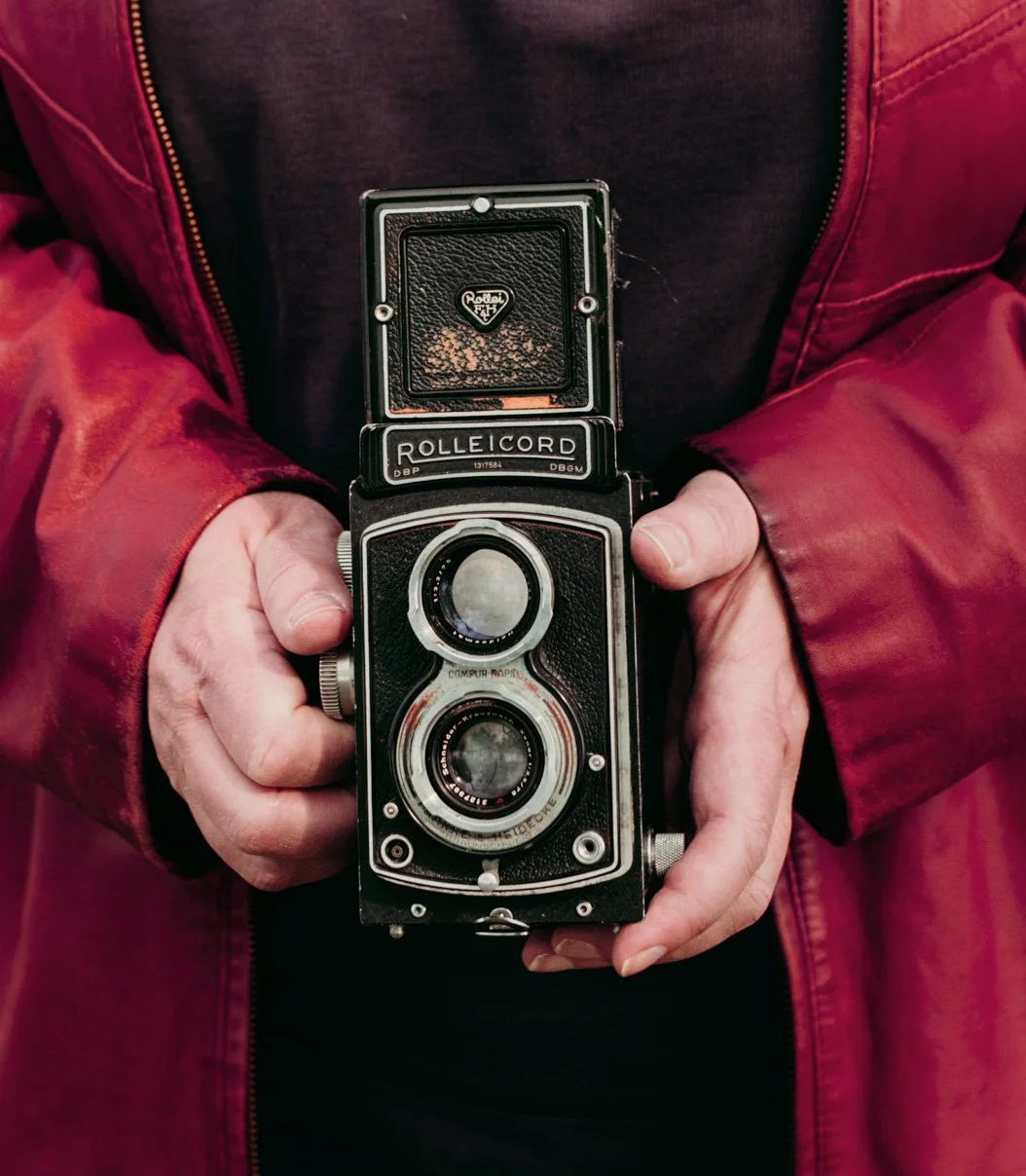 Old Rolleicord twin-lens reflex camera held in Dana's hands.