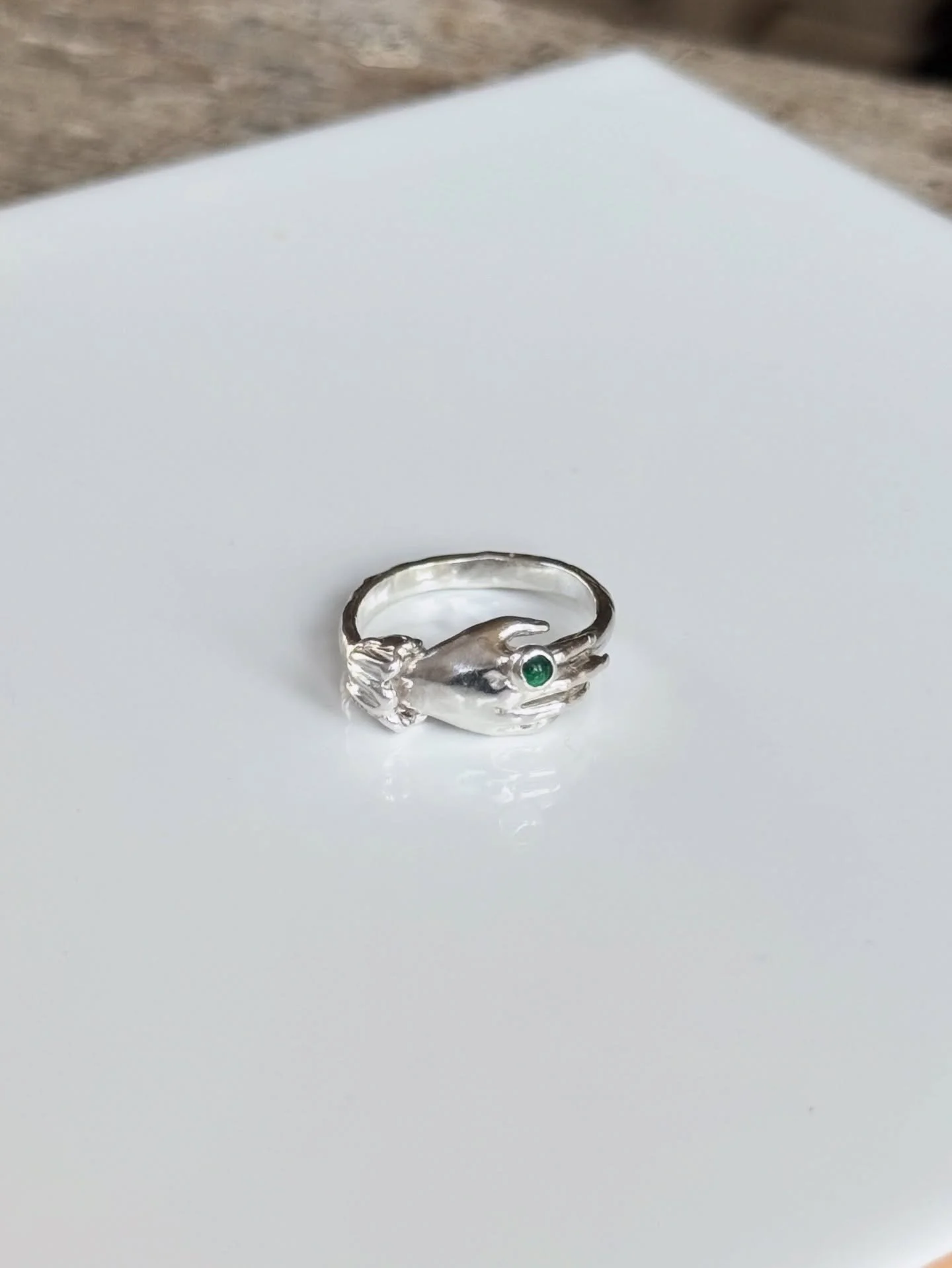 A comforting embrace from the Helping Hand Ring. Two slightly different variations on the band with a forest green emerald and green tourmaline. 

#gemstonejewellery 
#handring 
#handmadejewellery