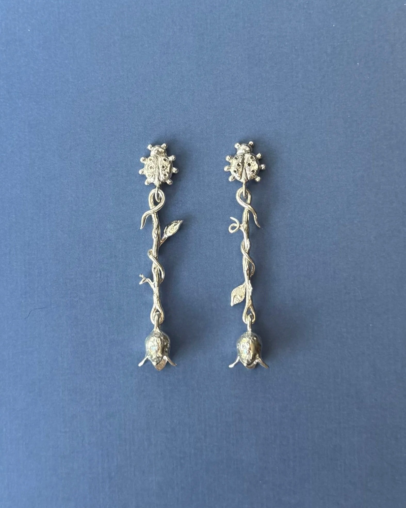 Silver ladybug earrings with vines and bluebells