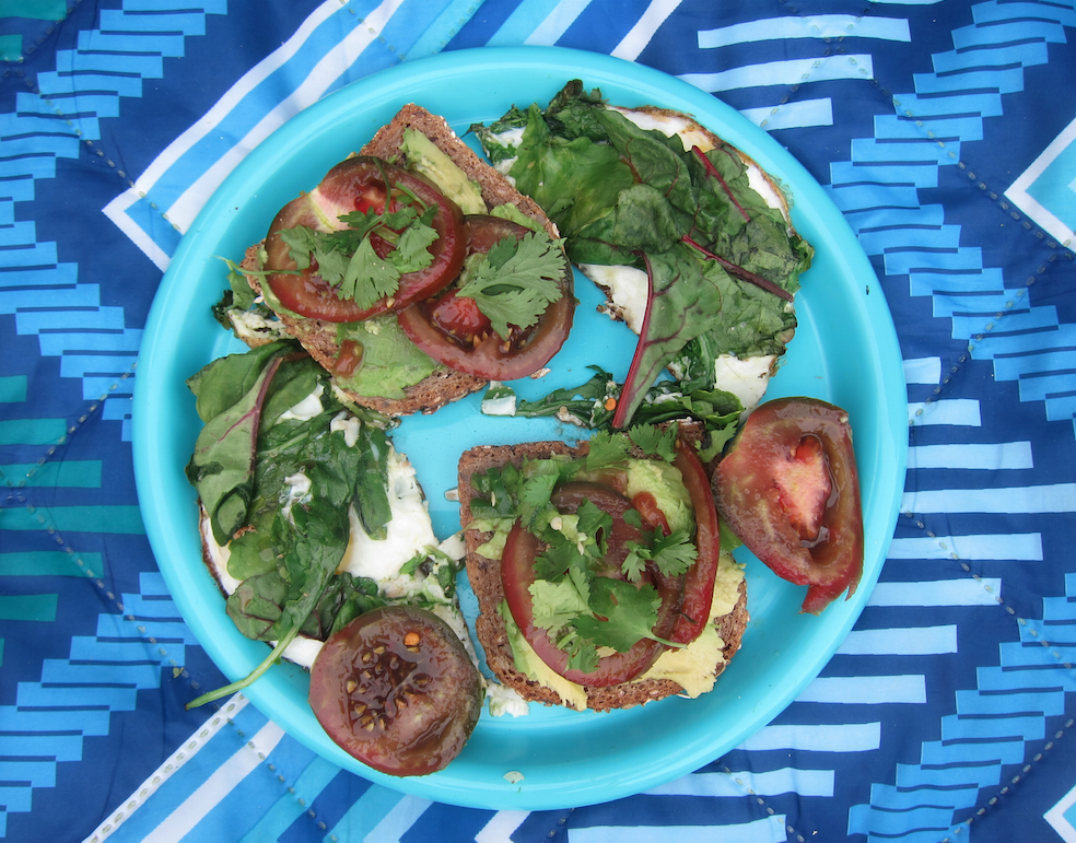 Eggs with heirloom tomato, kale, avocado breakfast sandwiches.