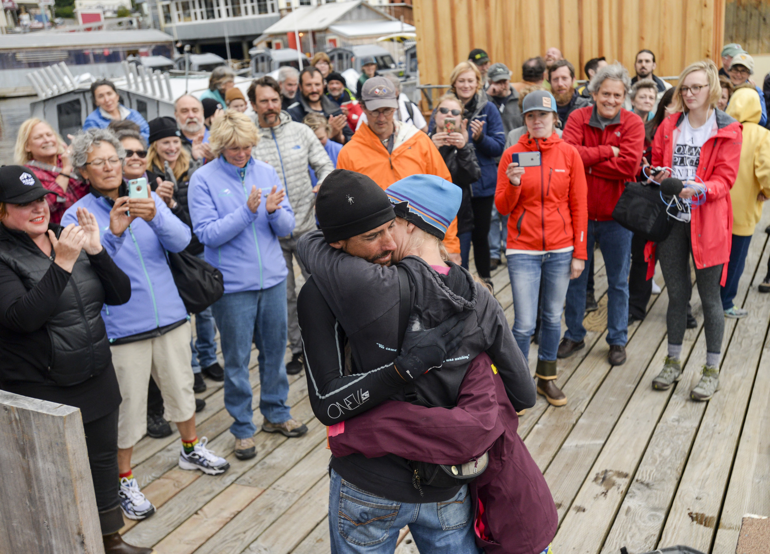  Karl Kruger — the first stand-up paddleboarder to finish the 750-mile Race to Alaska — embraces his wife Jessica Kruger and daughter Dagny Kruger as an amazed crowd applauds Sunday, June 25, 2017, in Thomas Basin. Karl, the lone member of Team Heart