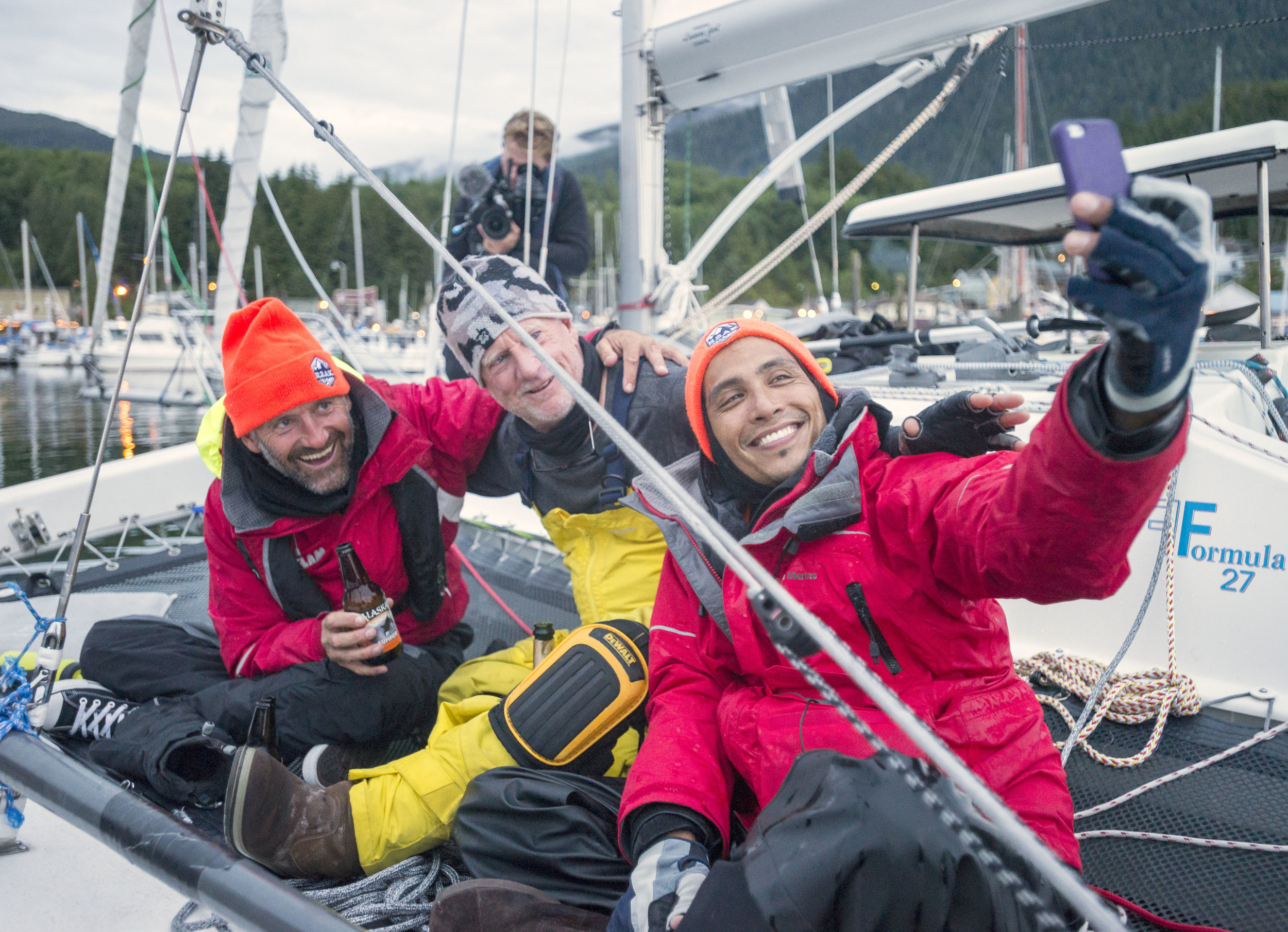  Team Alula member Zach Tapec, right, takes a selfie with captain Spike Kane, left, and Team Ain't Brain Surgery member Mark Eastham aboard their F-27 trimaran Tuesday after completing the Race To Alaska in Thomas Basin boat harbor. Team Alula, compr