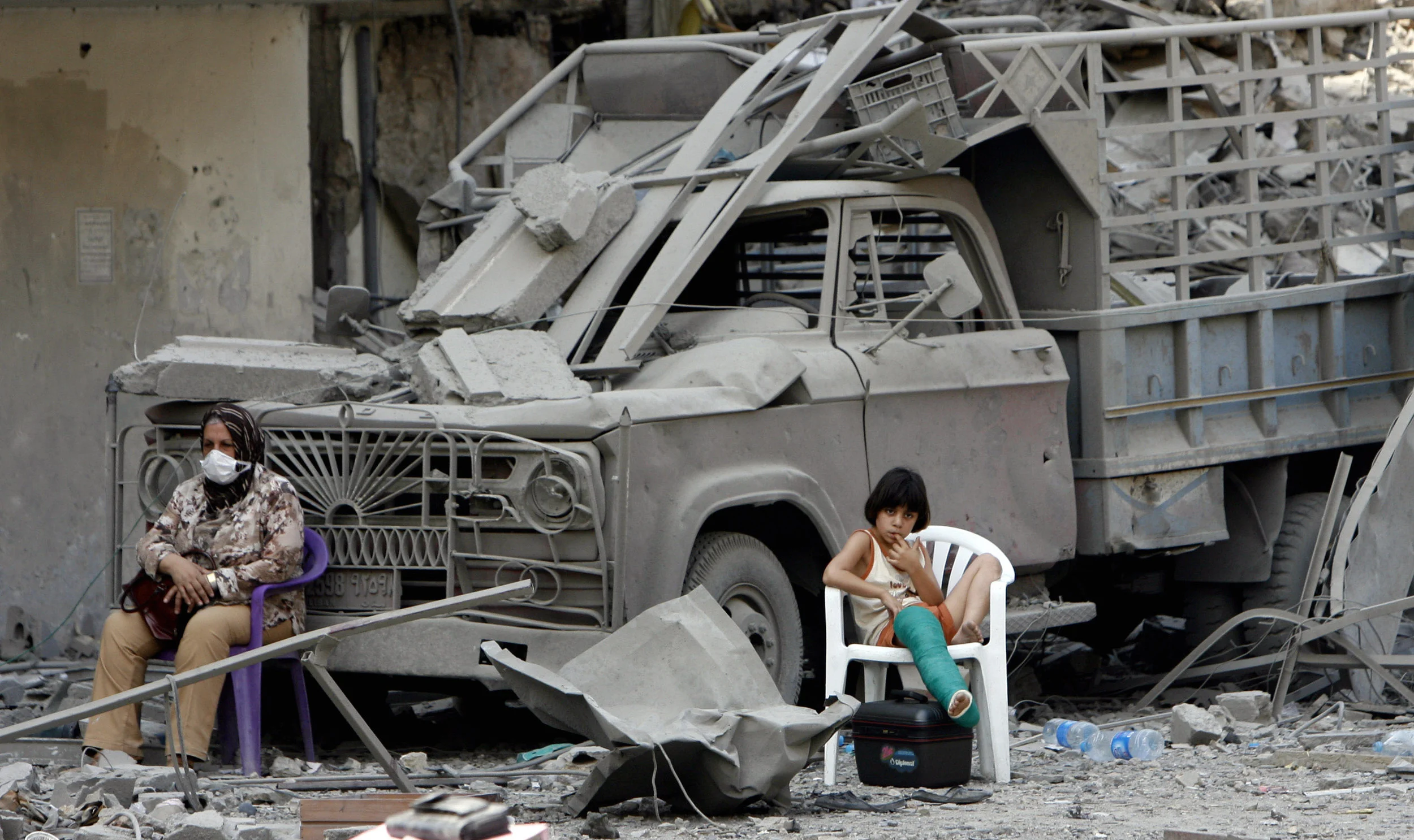 A Woman and child return to their damaged home after Israel ceased their weeks long bombardment of the Hezbollah stronghold of Dahia, Beirut, July 2006.