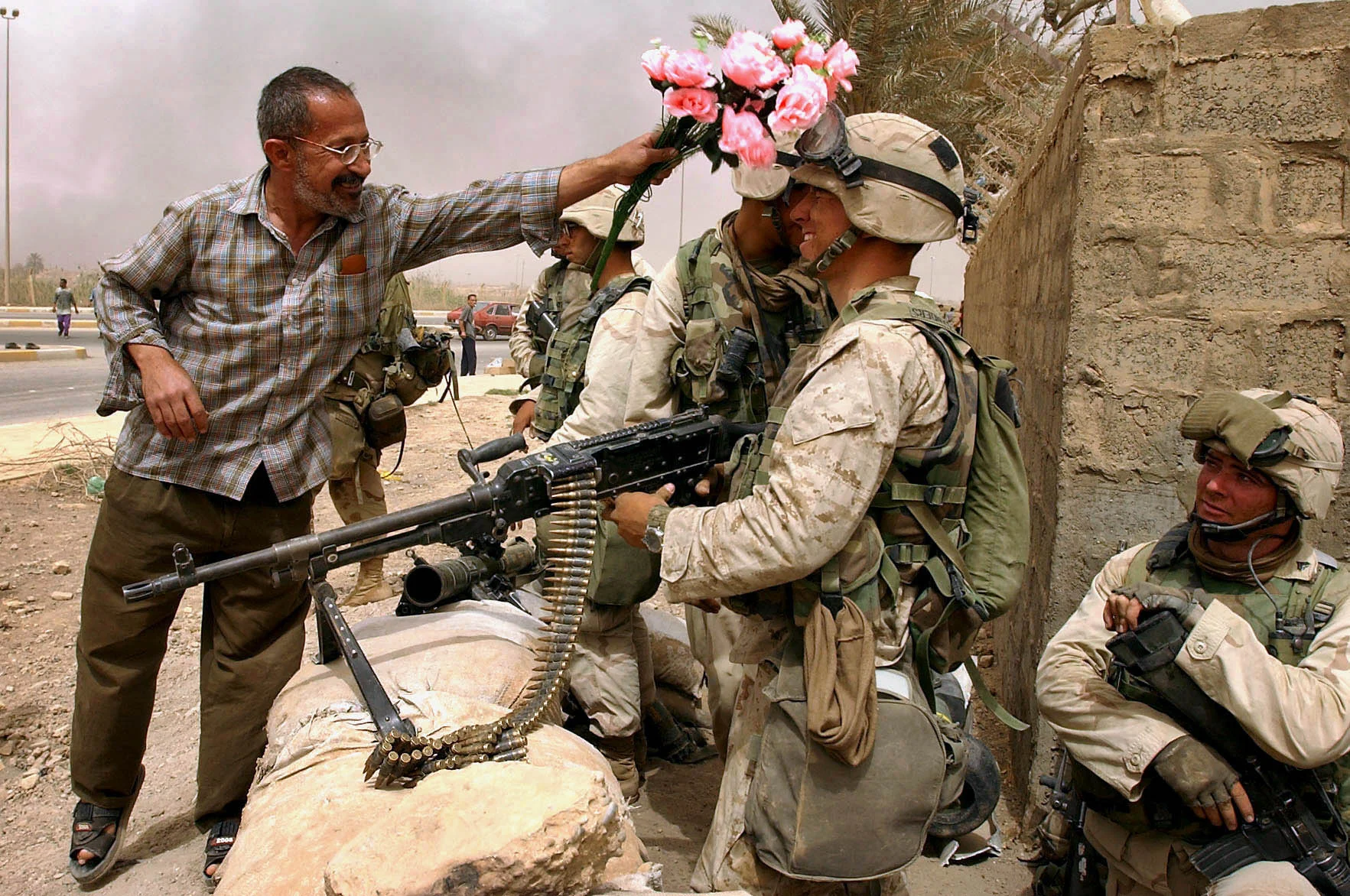 A Baghdad resident, relieved to see the arrival of U.S military, greets a soldier with a bouquet of artificial flowers close to Saddam City. Baghdad, Iraq, April 9, 2003.
