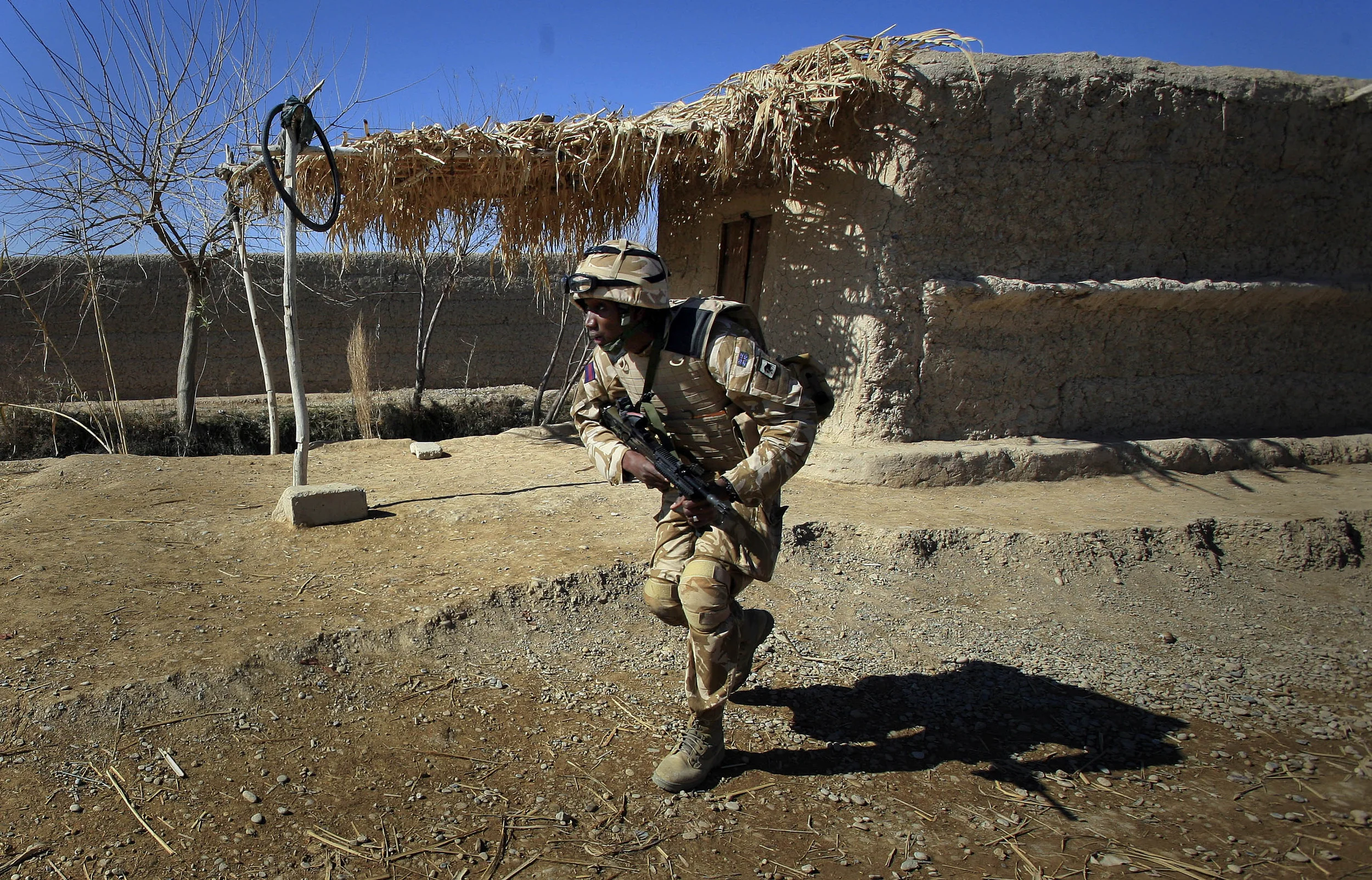  A soldier from the Grenadier Guards regiment runs for cover during a firefight with insurgents near to Lashkar Gah, Afghanistan, 2010. 