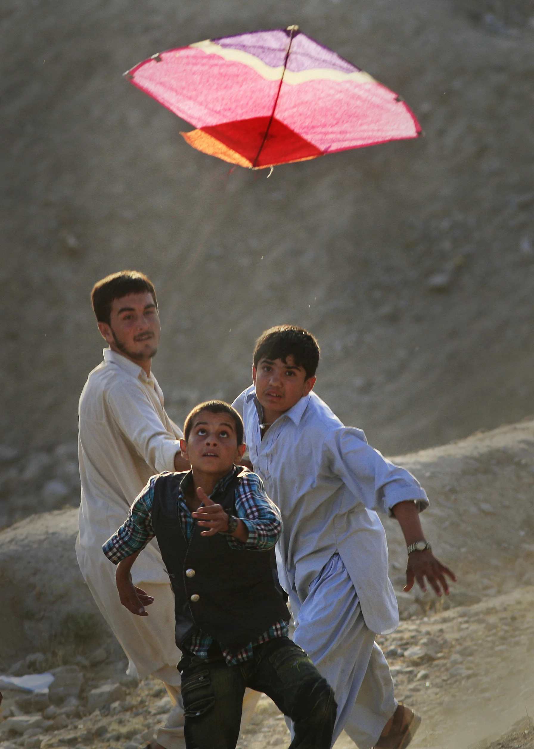  Young boys race to be first to catch a kite as it falls to the ground kite on Nader Khan hill in Kabul, Afghanistan, 2009. 