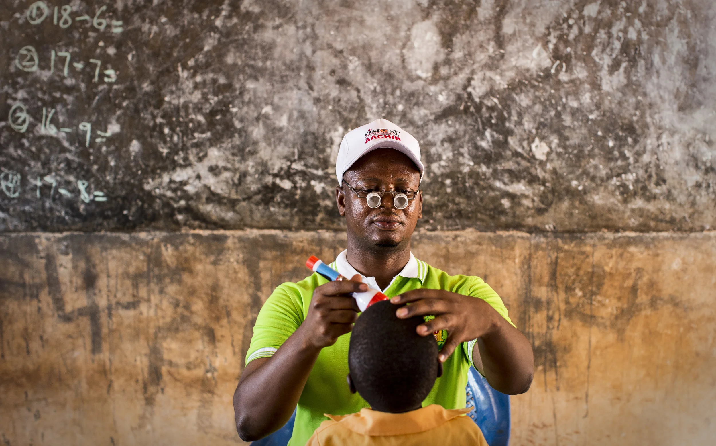 Opthalmic nurse, Iddrisu Abdulai, screens a child for trachoma at Zaari village school, Ghana. 'Sightsavers' works closely with the Ghanaian health service to prevent the disease. November, 2013.