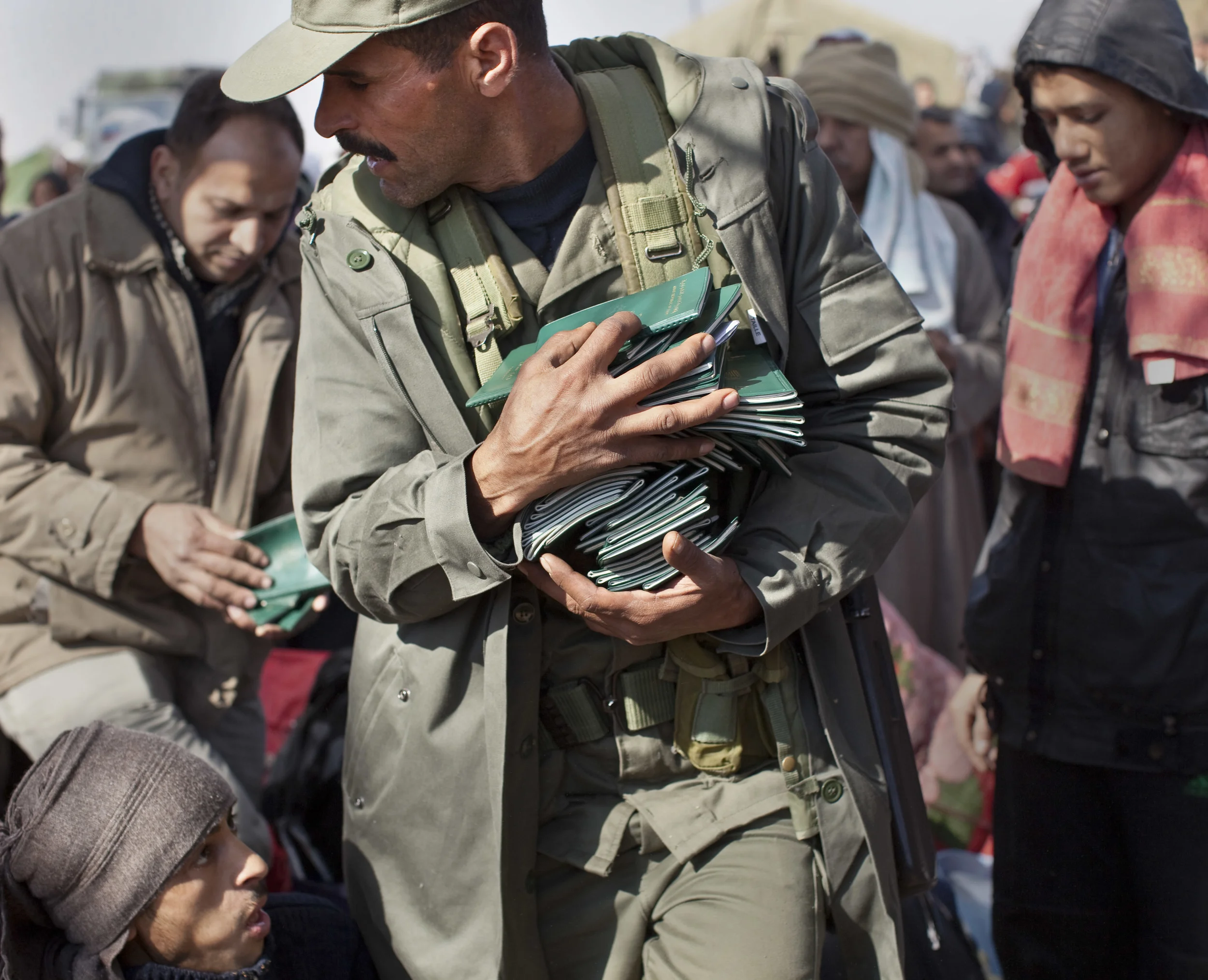  A Tunisian army officer collects passports of some of the thousands of Egyptian refugees who crossed the border from Libya to Tunisia. March 2011. 
