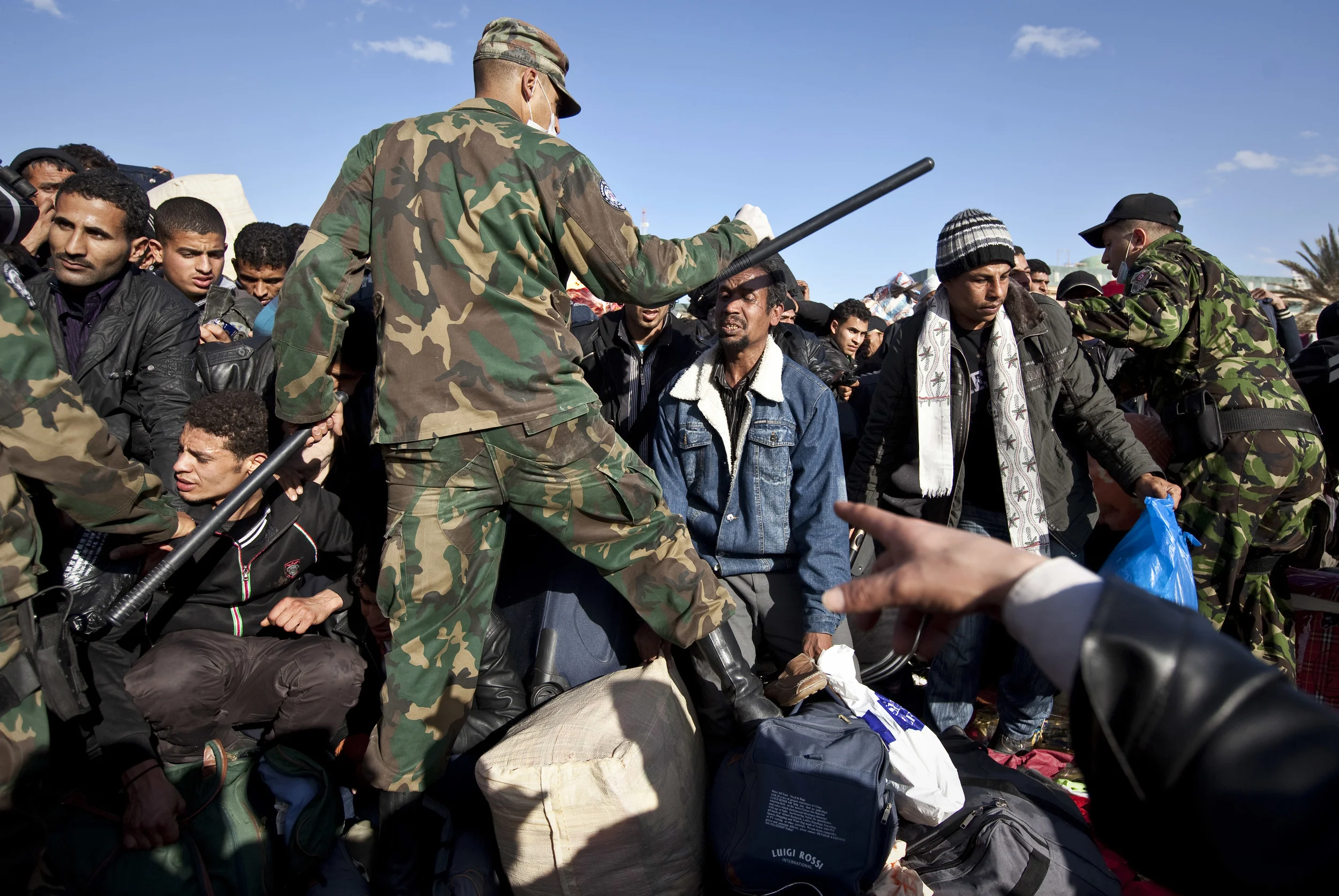  Tunisian soldiers control crowds of Egyptian refugees fleeing Libya, attempting to cross the border with Tunisia. March 2011. 