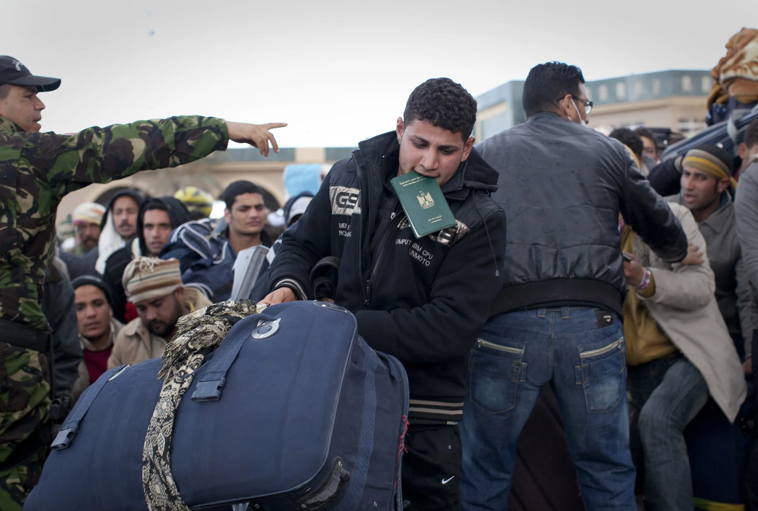  Tunisian soldiers control crowds of Egyptian refugees at the entry point into Tunisia from Libya as the crisis in Libya continues. March 2011.    