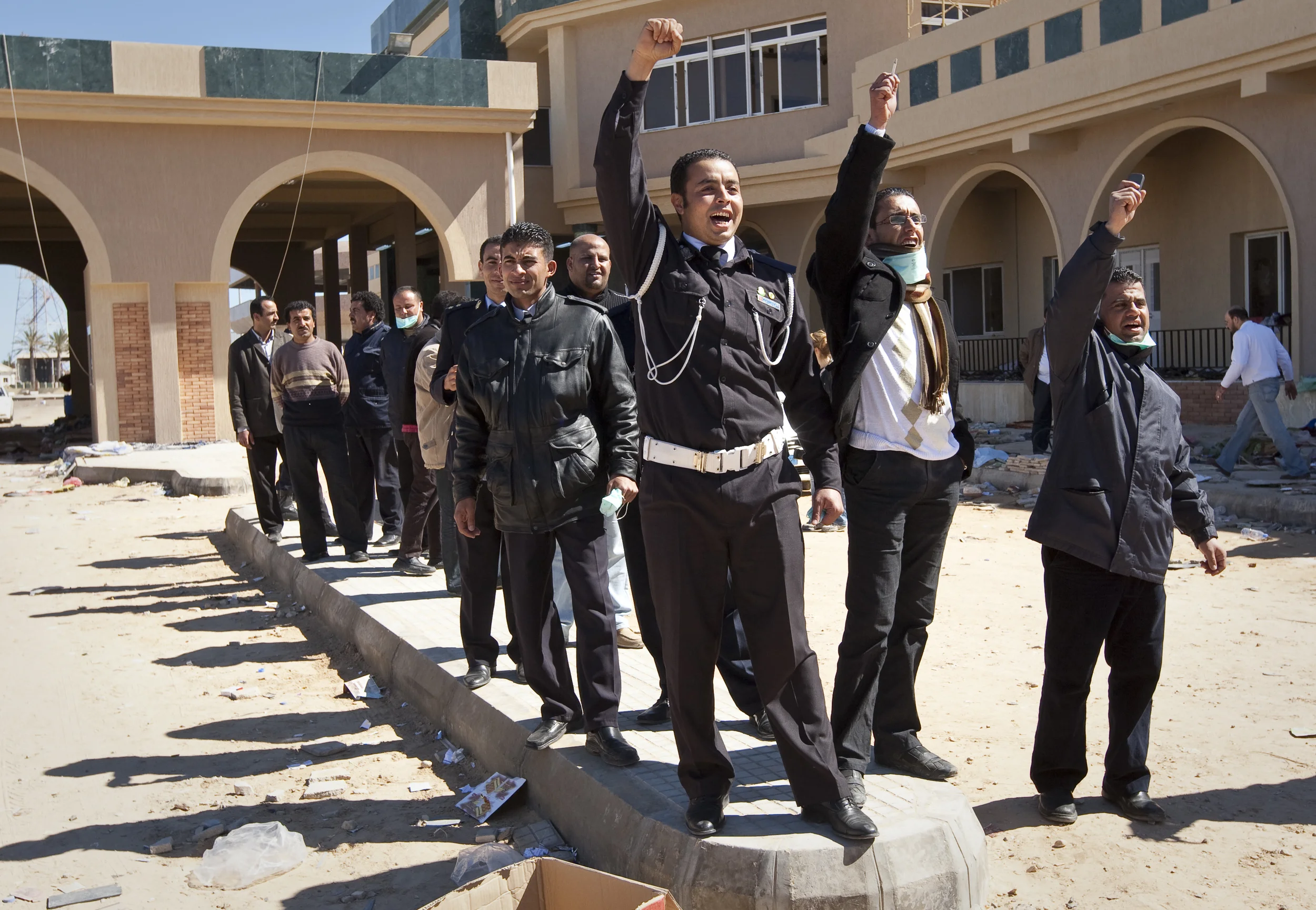  Libyan Police and officials at the Libyan border with Tunisia at Ras Jdir, offering to help fleeing refugees while they pledge their support for Col. Gaddafi. March 2011. 