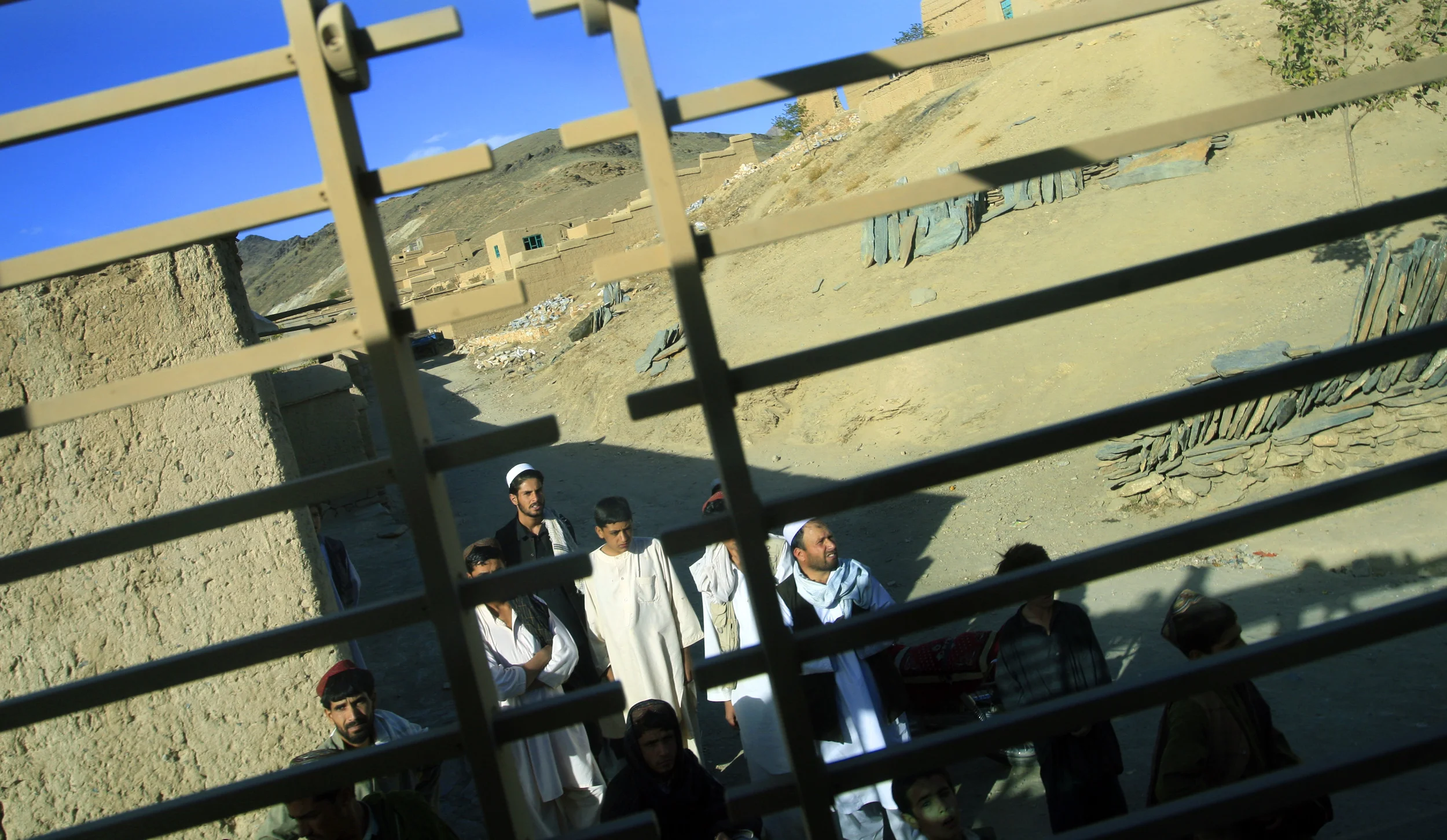 Villagers look on as a U.S. convoy passes through Tangi valley, Wardak, Afghanistan, 2009.