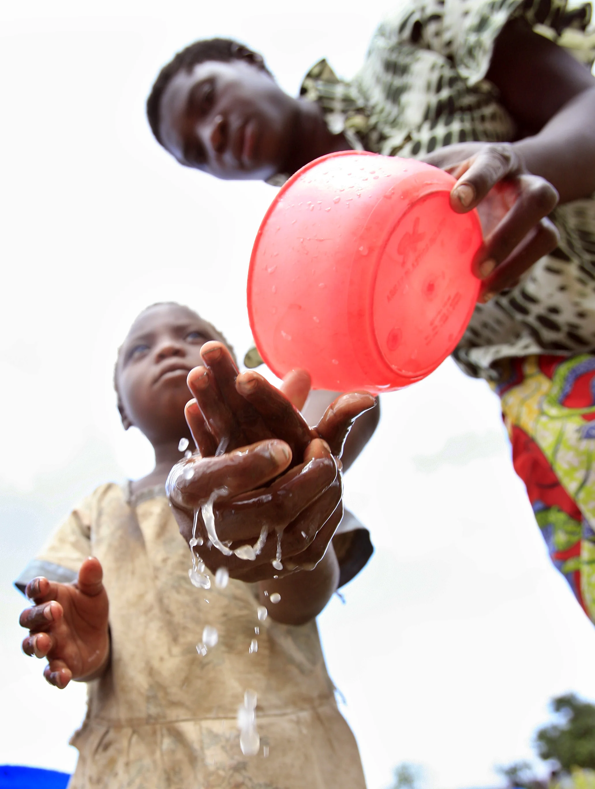  An orphan is helped with washing her hands in the village of Chamadinga, Malawi. &nbsp;The charity 'Pump Aid' installed a water pump, to help the village provide clean water for the hundreds of orphaned children. &nbsp;November 2008. 