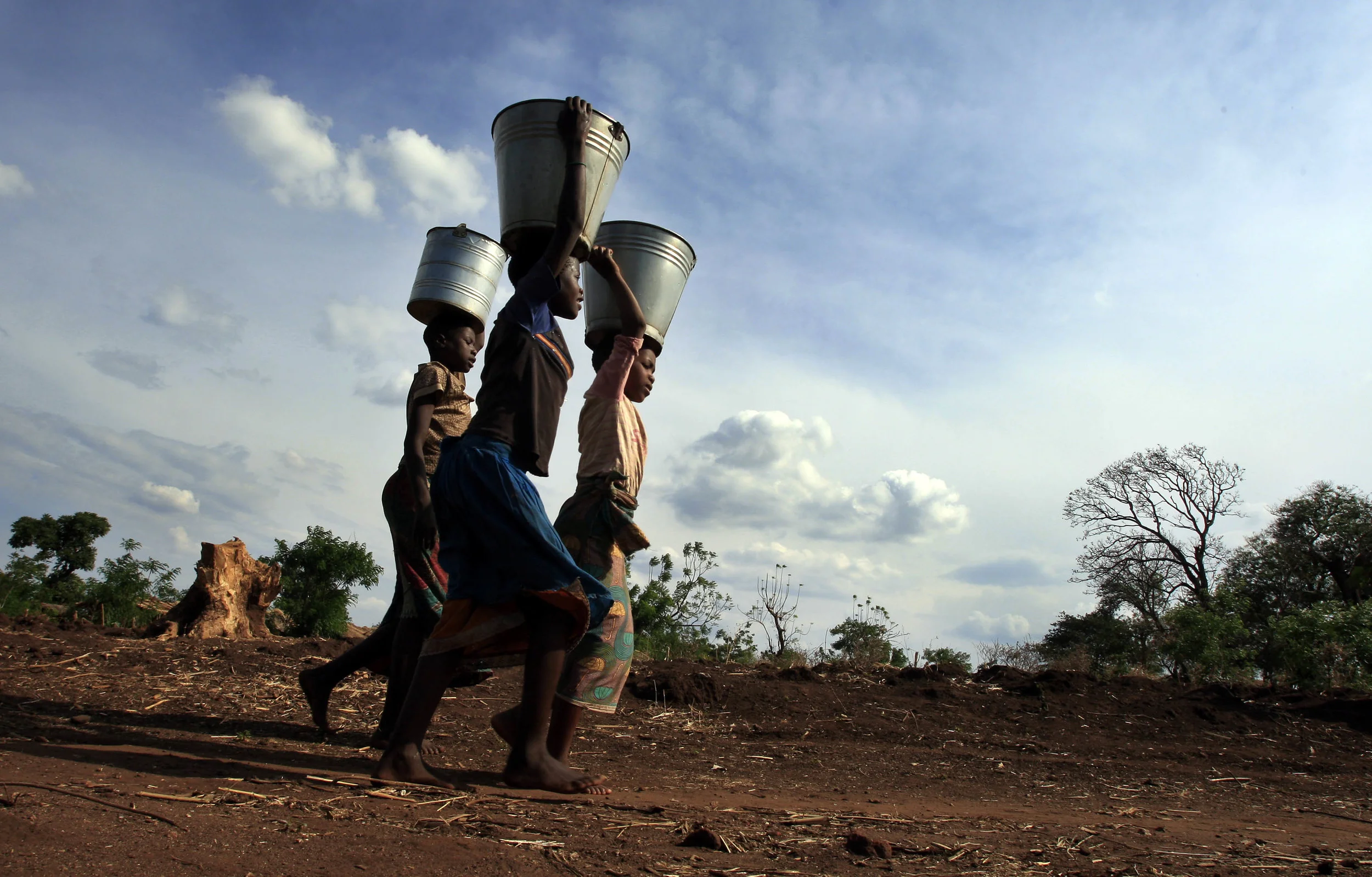 Girls from the village of Mwachilolo, Malawi, return after filling buckets from a 'Pump Aid' Elephant water pump. &nbsp;November 2008. 