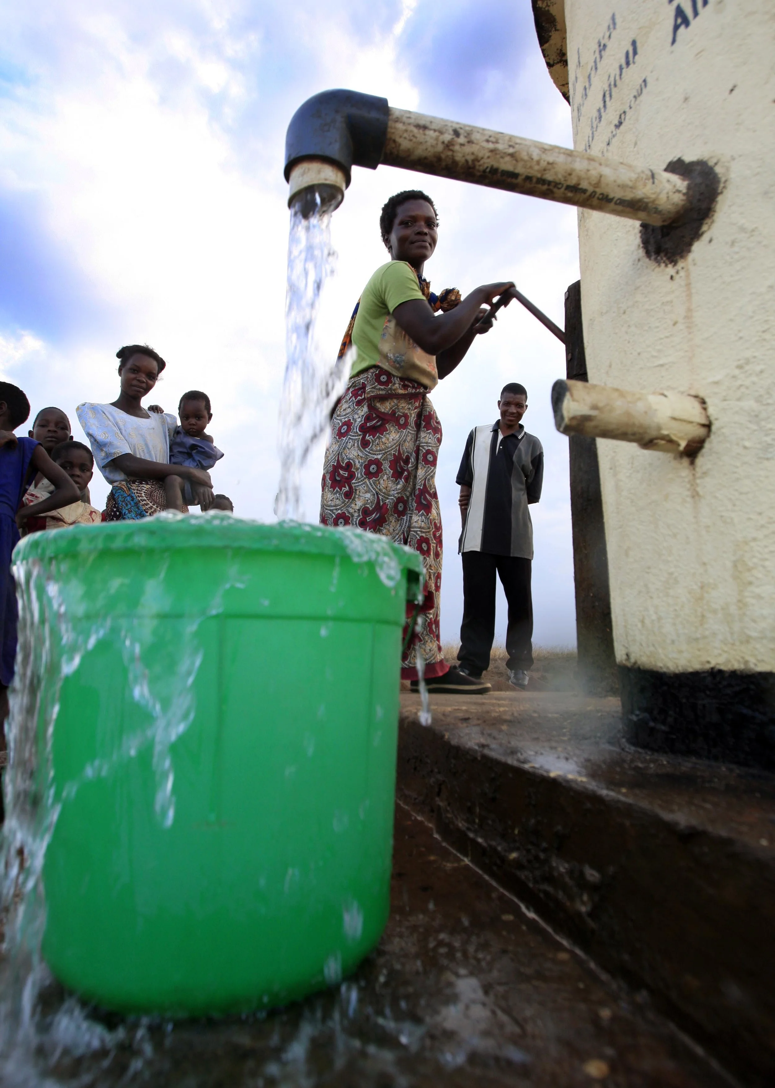  A woman in the village of Kaloumba, Malawi, filling buckets with water from 'Pump Aid' Elephant water pump. November 2008. 