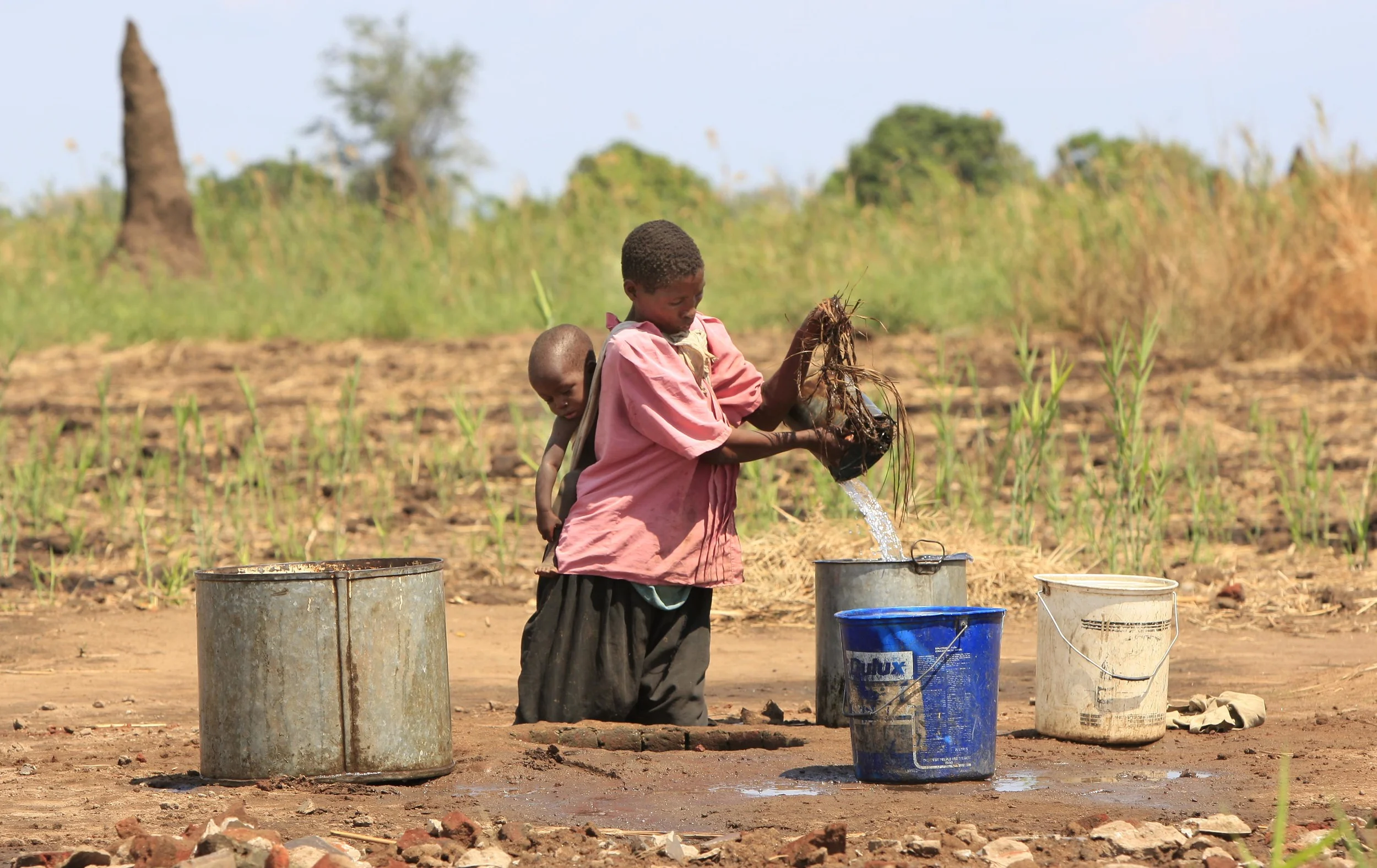  Eznat Nzoza, mother of four, takes water from a decaying well in the village of Paulo, Malawi. 'Pump Aid' replaced it with an Elephant pump. &nbsp;November 2008. 