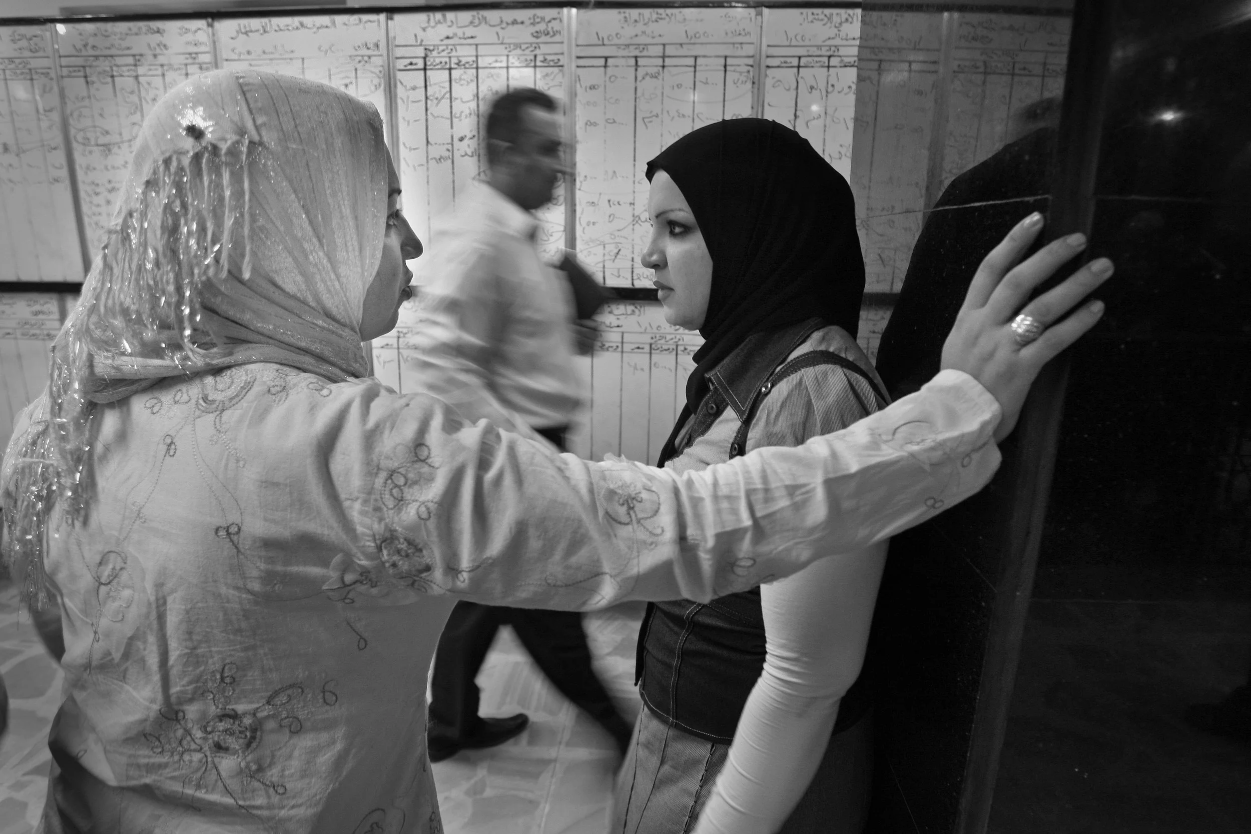 Women trading floor workers at the Iraqi stock exchange in Baghdad by the main the trading board, during a morning session. March, 2009.