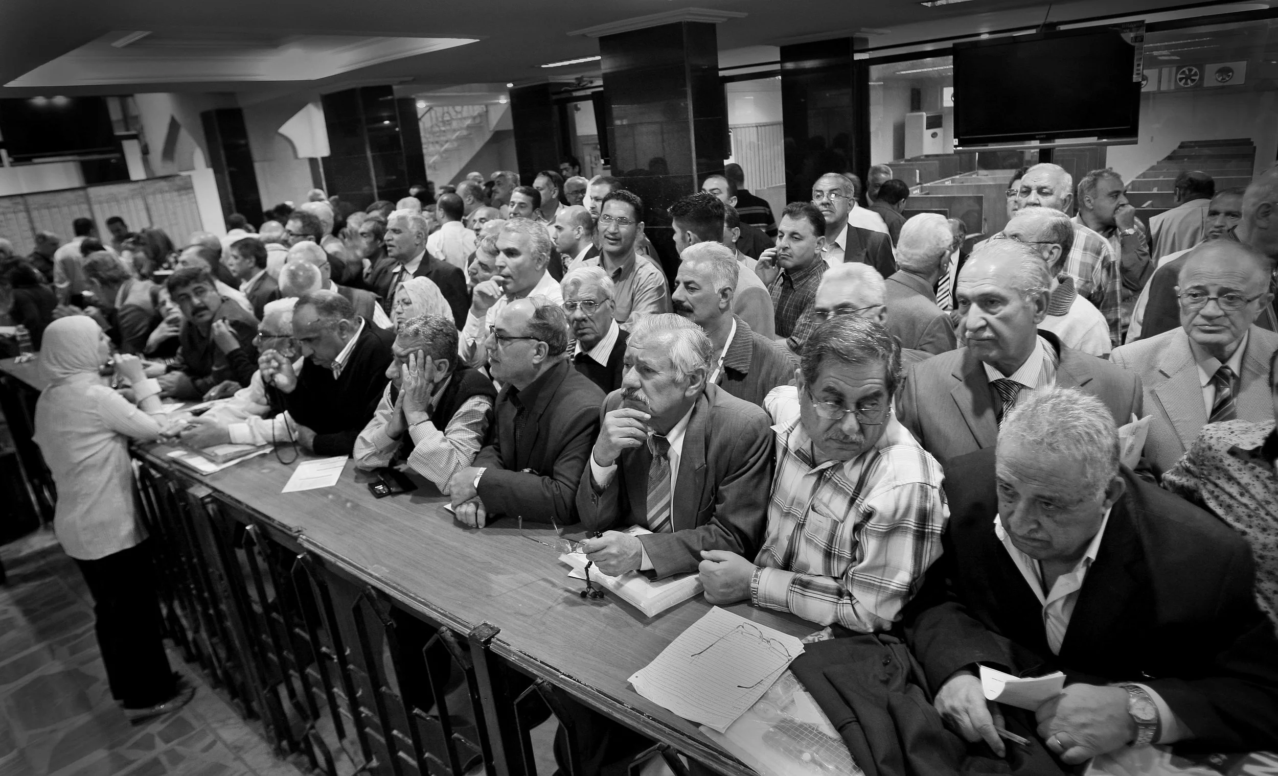 Investors at the Iraqi stock exchange in Baghdad conducting business during a morning trading session. March, 2009.