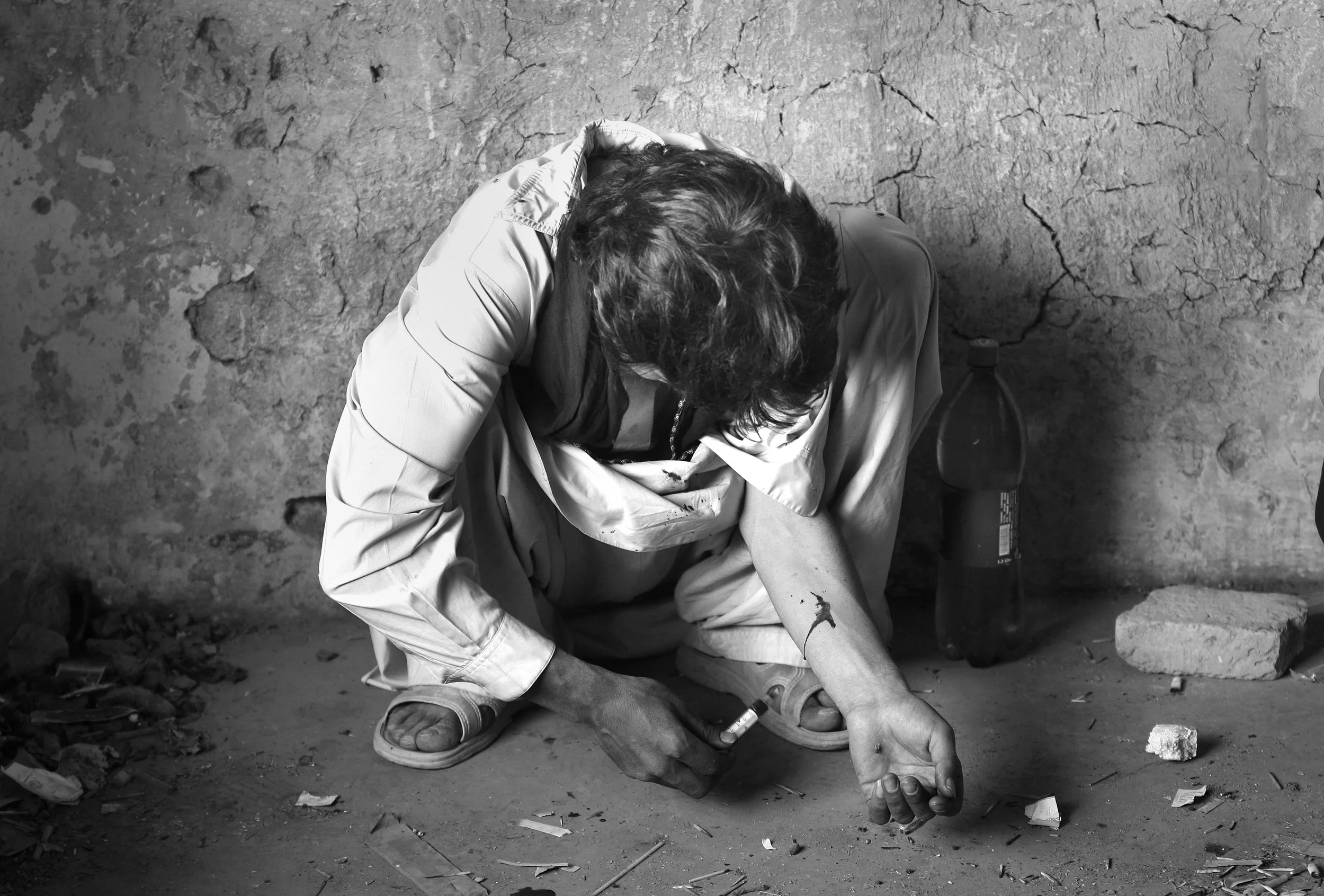  A heroin user injects himself with a dirty syringe and broken needle in the destroyed, former Russian Cultural Centre, a haven for drug addicts in Kabul, Afghanistan. &nbsp;September, 2009. 