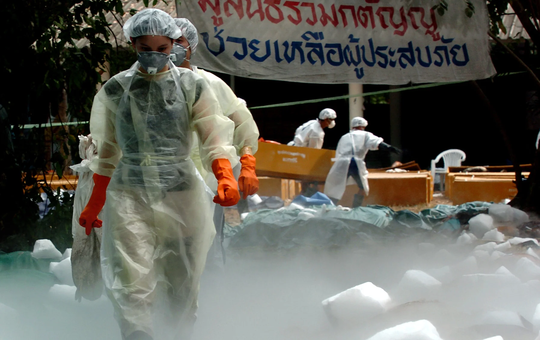  Thai and foreign volunteers assist with the laying out of bodies under dry ice at a Buddhist temple near Khao Lak, Thailand, 2005, following the Asian tsunami, christmas 2004. 