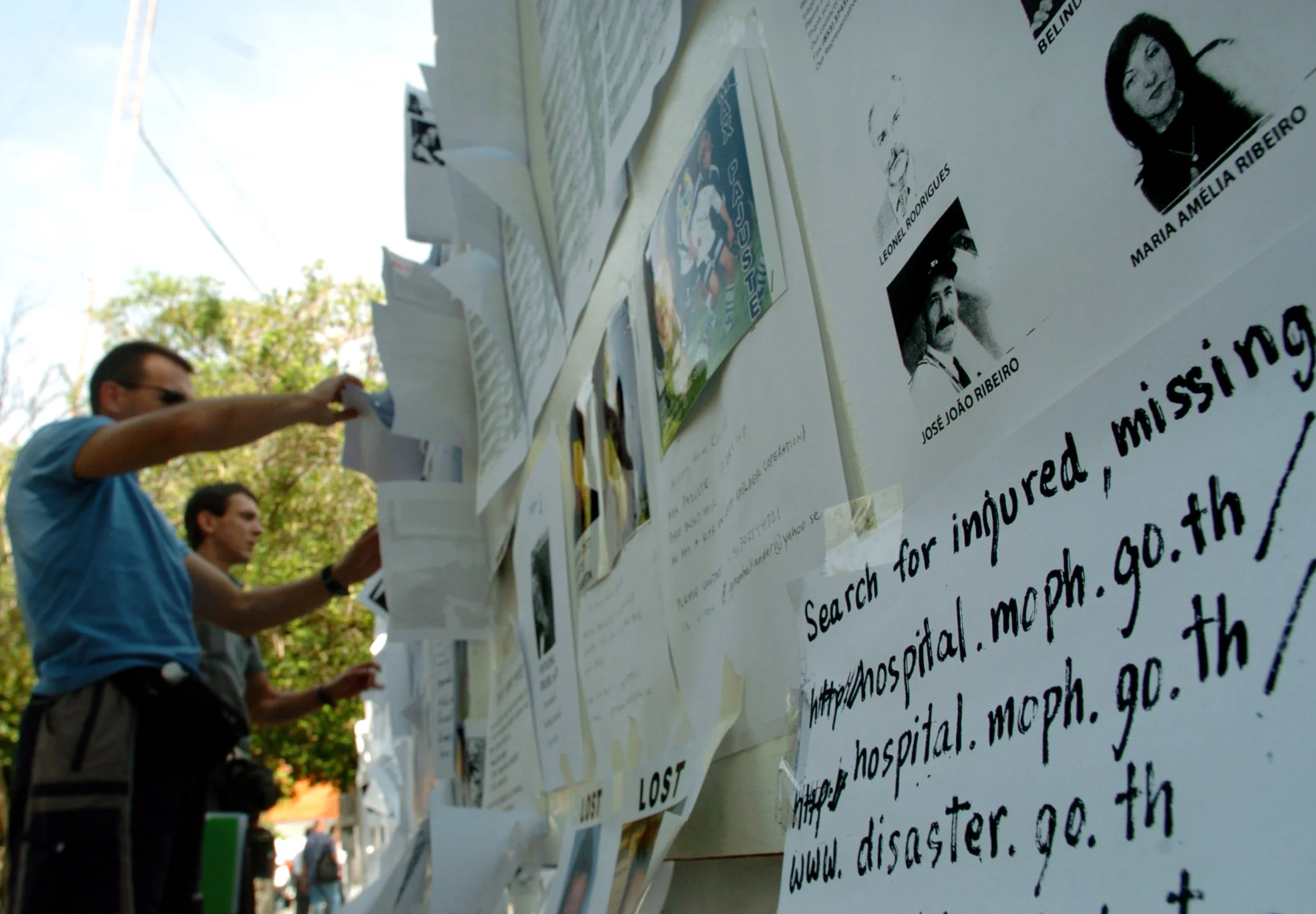  Following the Asian tsunami of Christmas 2004, people seek information of missing loved ones and friends posted on an information wall in Phuket, Thailand. January 2005.&nbsp; 