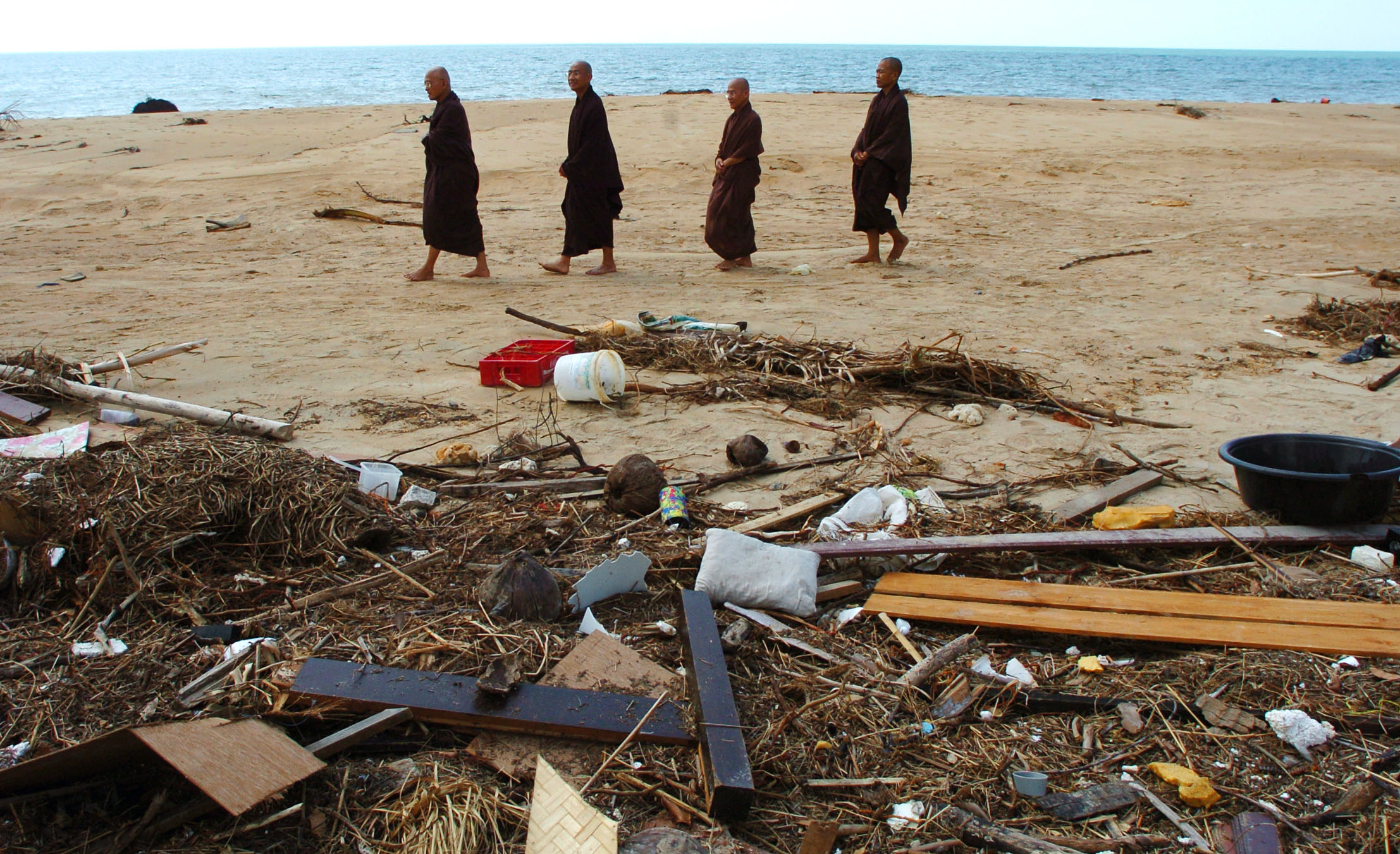  Buddhist monks in Khao Lak, Thailand, walk the beaches where the Christmas 2004 tsunami struck, in their attempt to cast away the bad spirits they felt were present in the aftermath. January 2005. 
