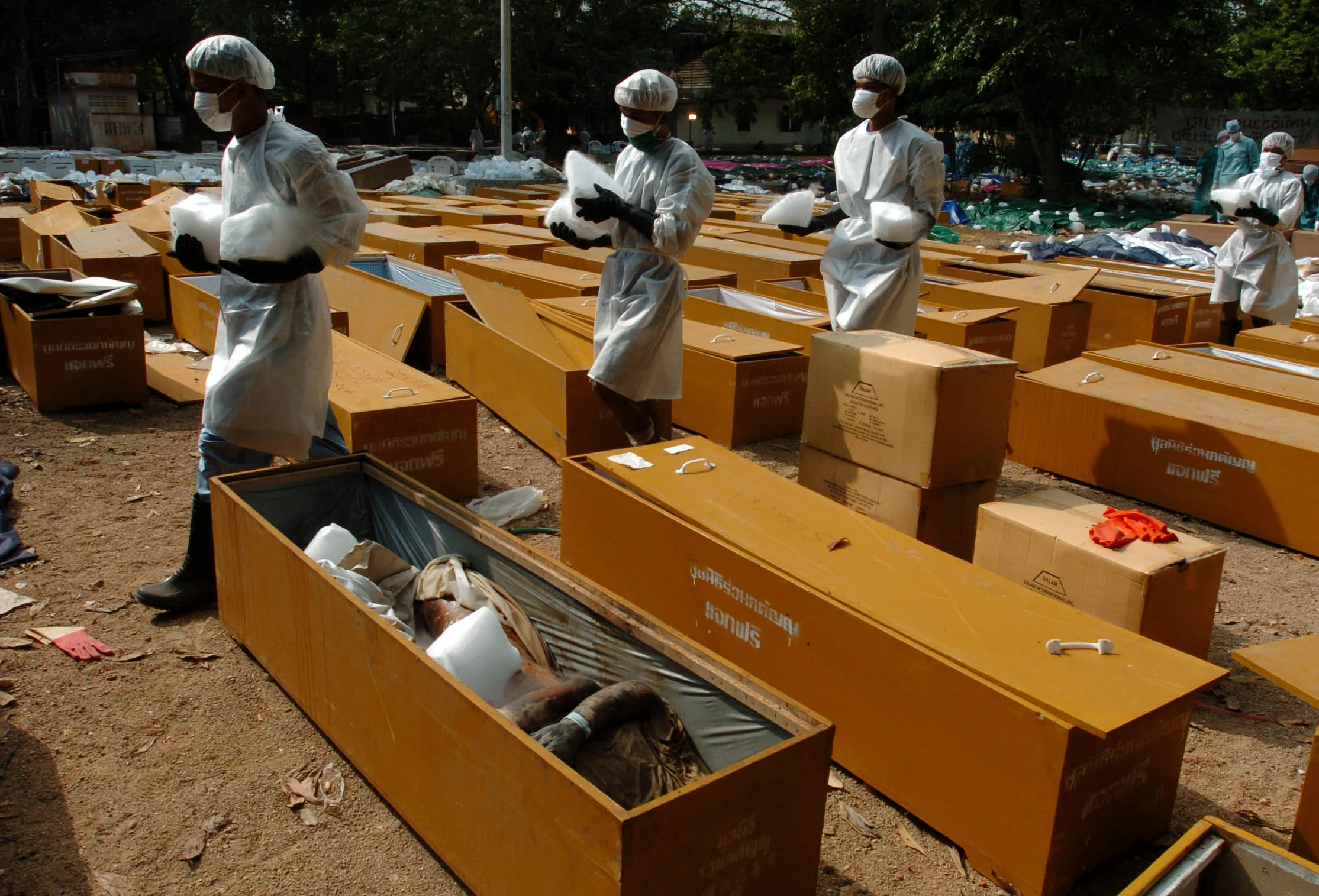  Thai and foreign volunteers assist with the laying out of bodies under dry ice at a Buddhist temple near Khao Lak, Thailand, 2005, following the Asian tsunami, christmas 2004. 