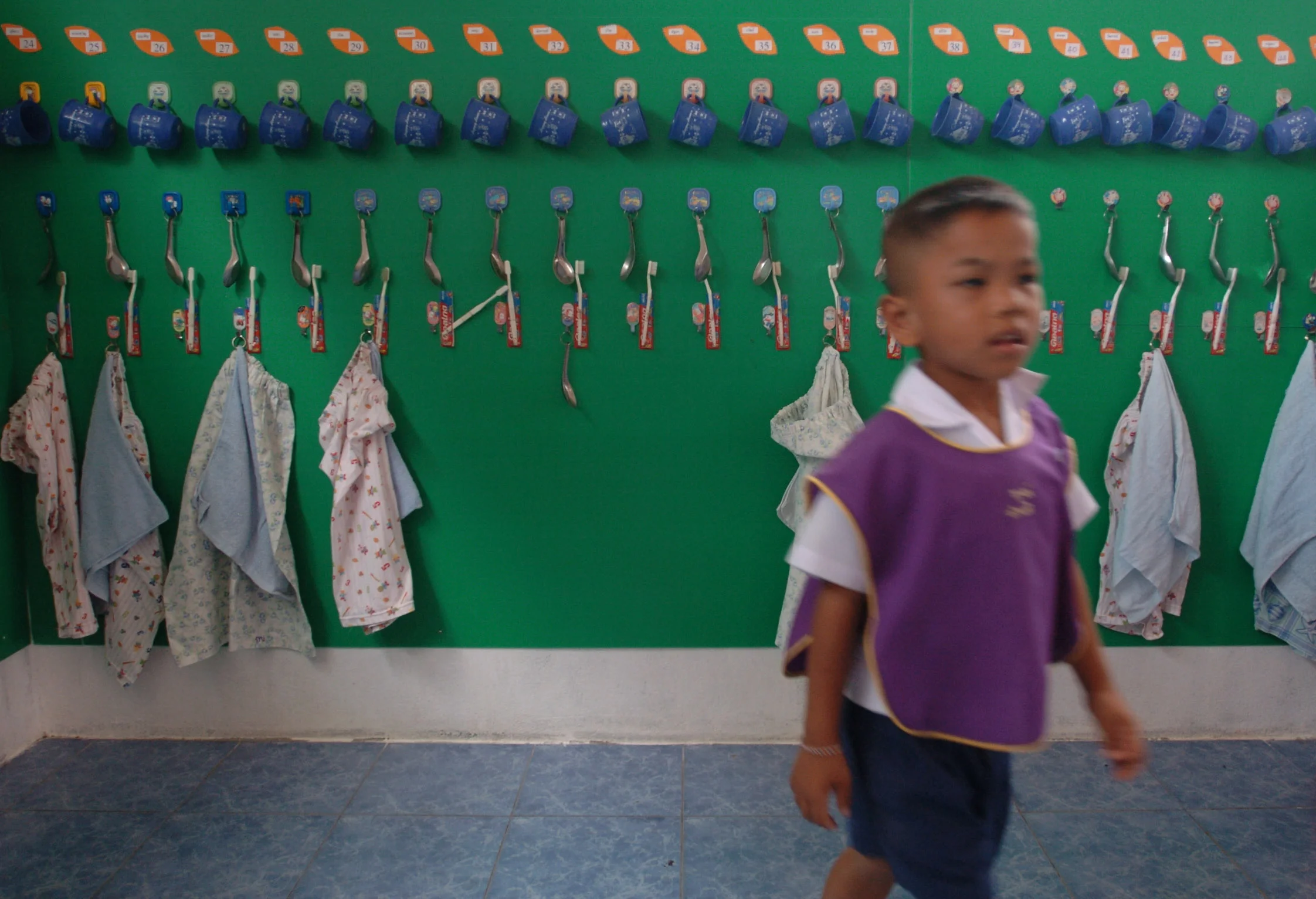  Aprons hang on pegs in a school room of some of the children missing following the Christmas 2004 Asian tsunami. Khao Lak, Thailand 2005. 