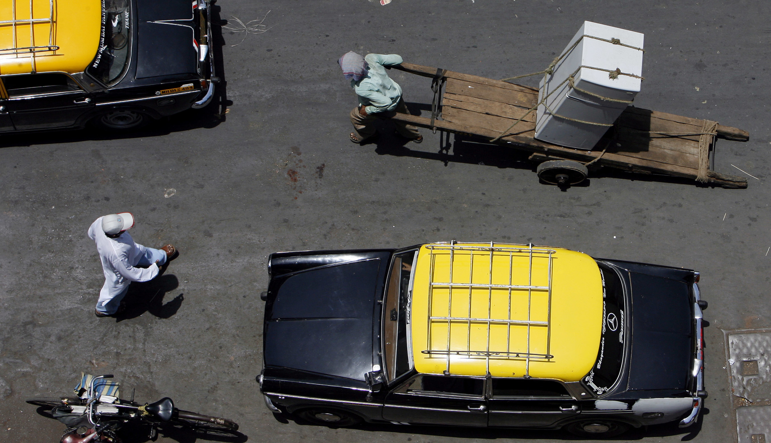  Pedestrians, barrow pushers and taxis share the main roads in Chor Bazaar, Mumbai, India. May, 2006. 