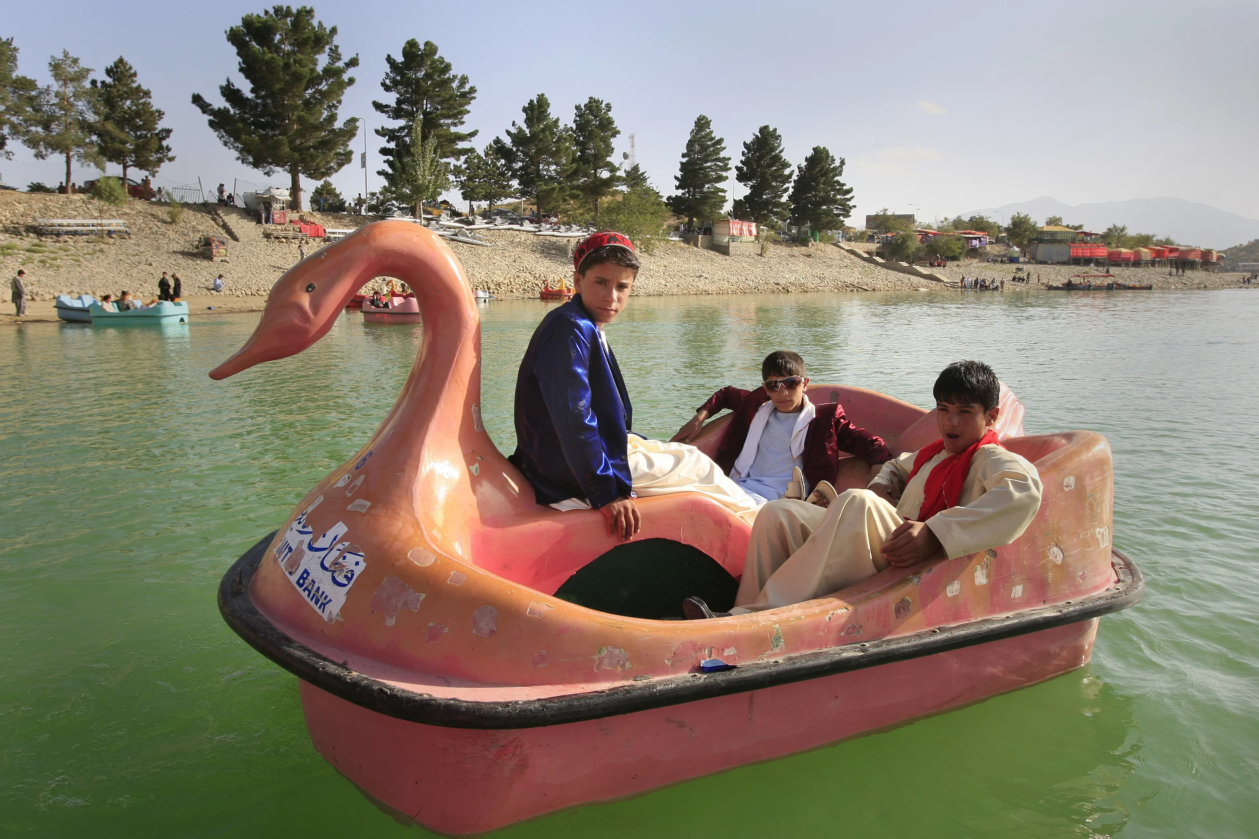  Young boys, dressed up for the first day of Eid el-fitr, play in a 'Swan' pedalo on Lake Qargah, outside of Kabul, Afghanistan, 2009. 