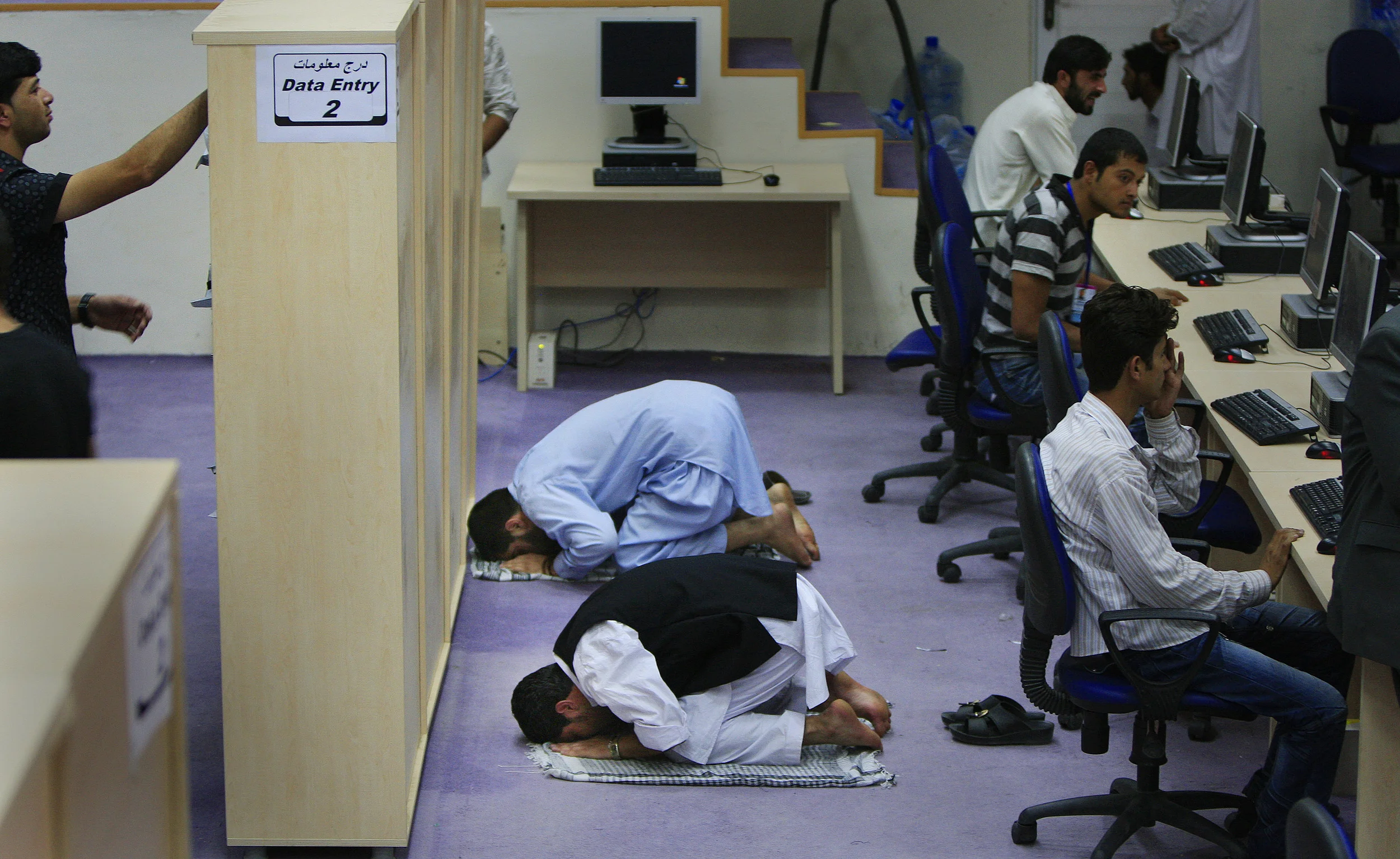  Vote counters pray at the Independent Election Commission's tally centre, Kabul, Afghanistan, 2009. 