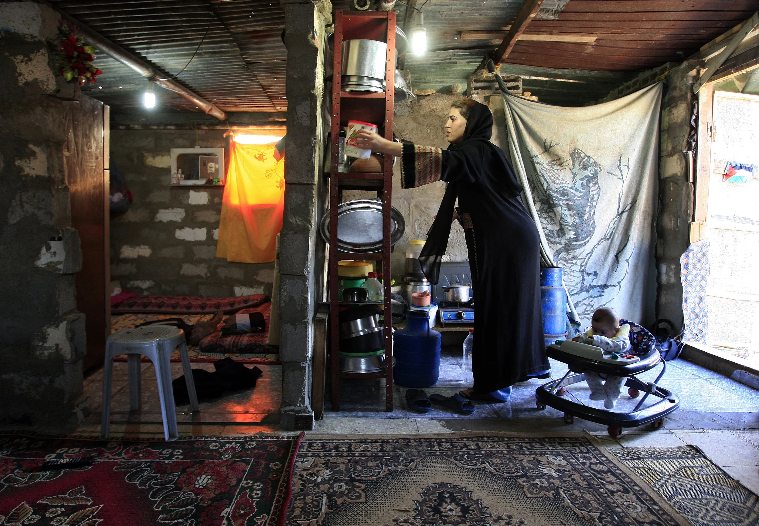  A refugee Gazan woman and her baby inside their home made from building blocks reclaimed from destroyed buildings. &nbsp;Northern Gaza, December 2009. 