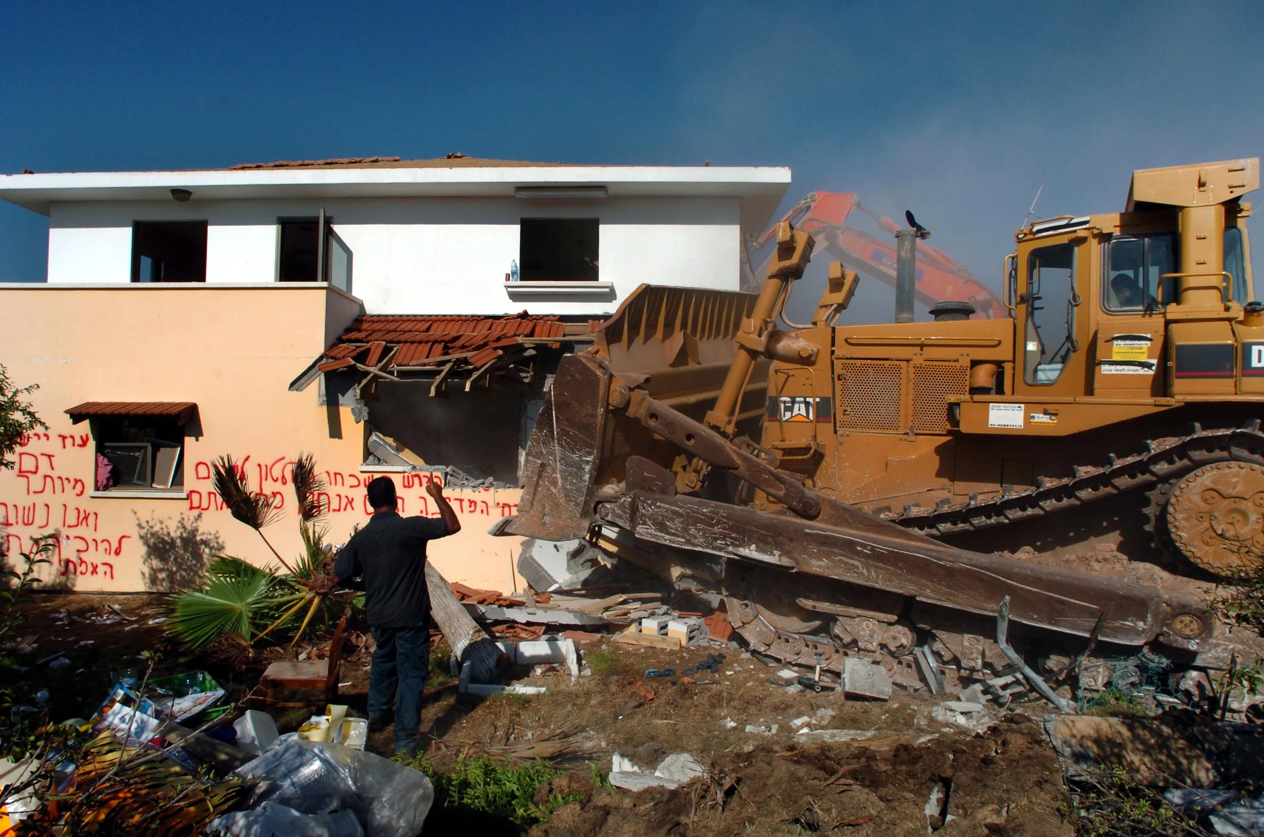  An Israeli demolition team destroys houses in Gush Qatif that settlers have been forced to leave as part of the disengagement from Gaza. August 2005. 