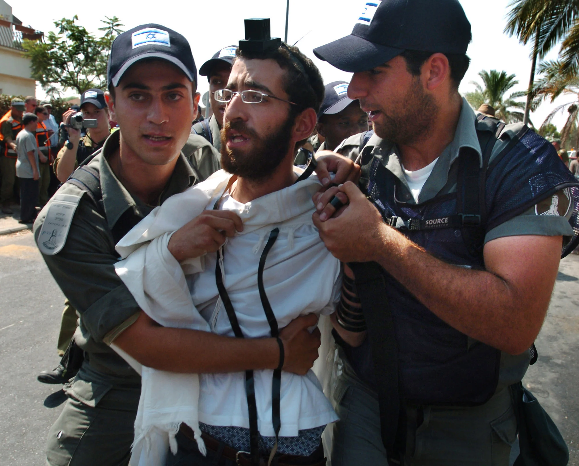  A young settler being forcibly led to a waiting bus as he is removed from Newe Dekalim, as part of Israel's disengagement from Gaza. &nbsp;August 2005. 