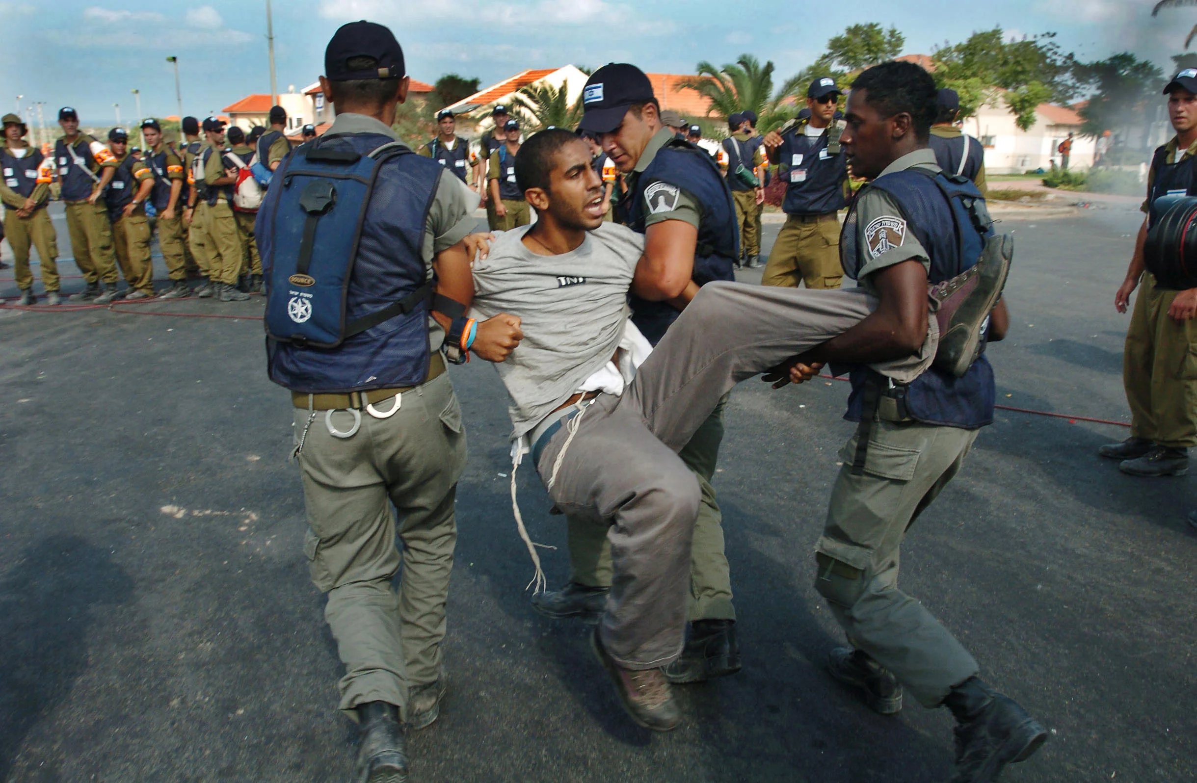  A young settler being forcibly led to a waiting bus as he is removed from Newe Dekalim, as part of Israel's disengagement from Gaza. &nbsp;August 2005. 