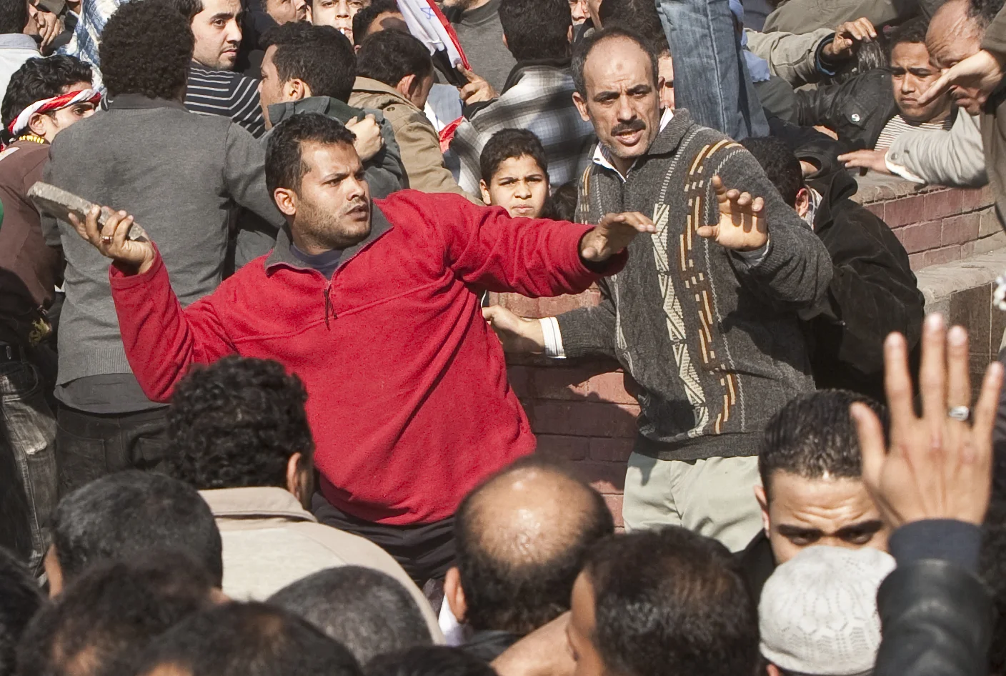  A pro Hosni Mubarak demonstrator throws a slab of concrete towards anti-Mubarak crowds at the start of rioting in Tahrir square, Cairo, 2011. 