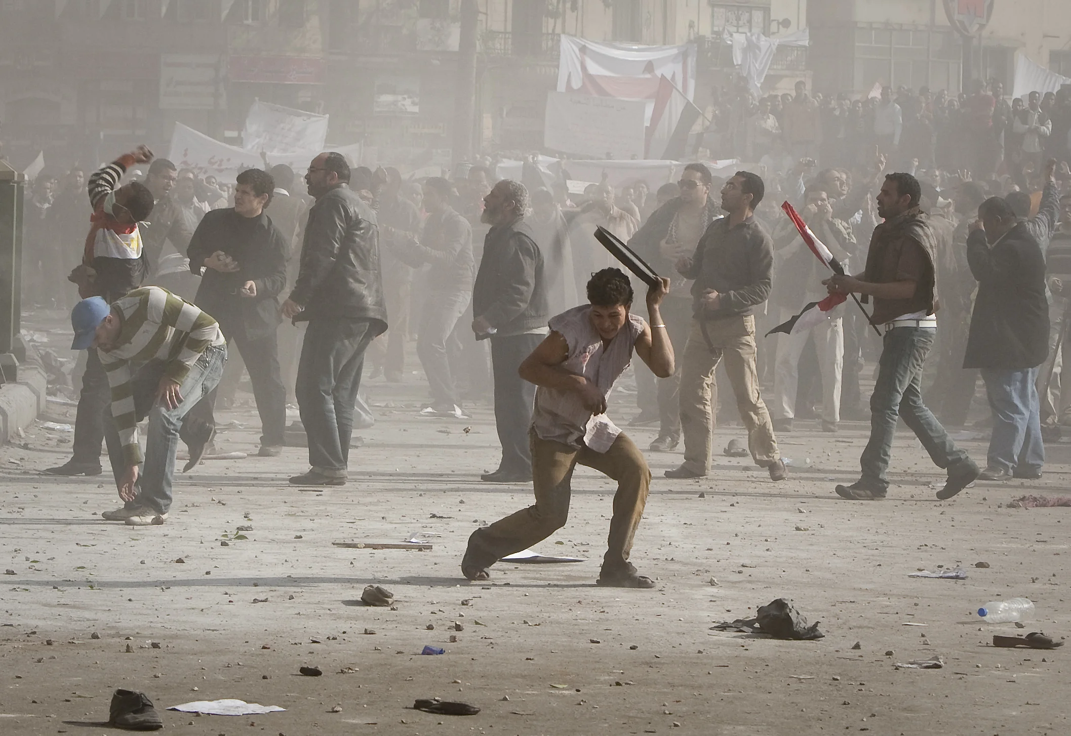  Anti Mubarak protesters shield themselves and throw rocks back during rioting with pro Mubarak groups in Tahrir square, Cairo, 2011. 