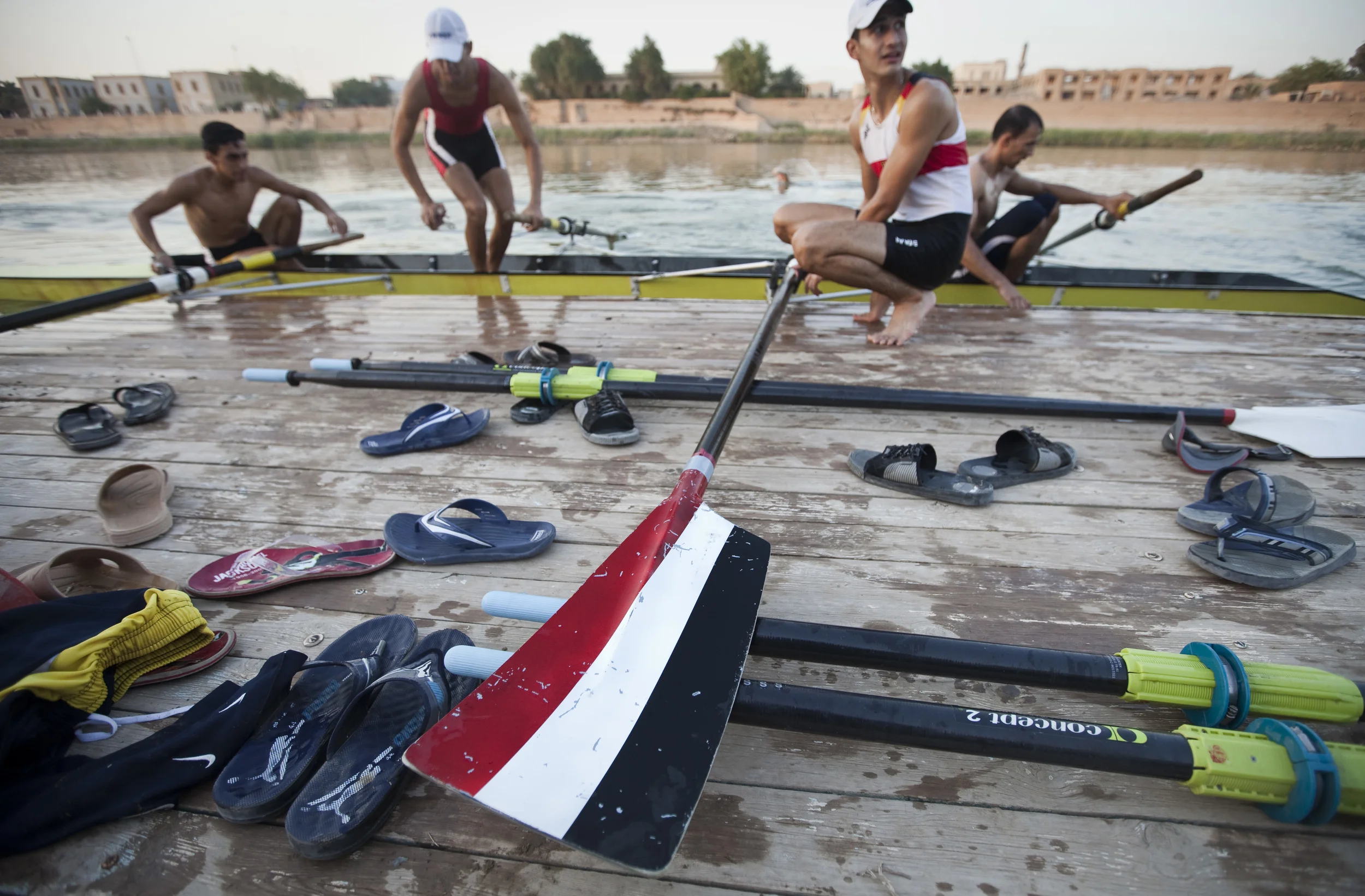  The Iraqi national coxless four rowing team leave the river Tigris after a training session. The Iraqi flag on their rowing blades. Baghdad, August 2010. 
