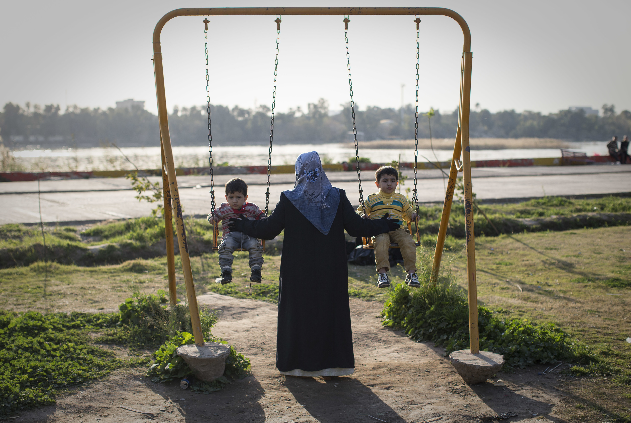  A mother with children enjoy the start of the weekend at a fun-fair on the banks of River Tigris, Baghdad. Almost ten years previously, the U.S. army were 'liberating' the city. &nbsp;March 2013. 
