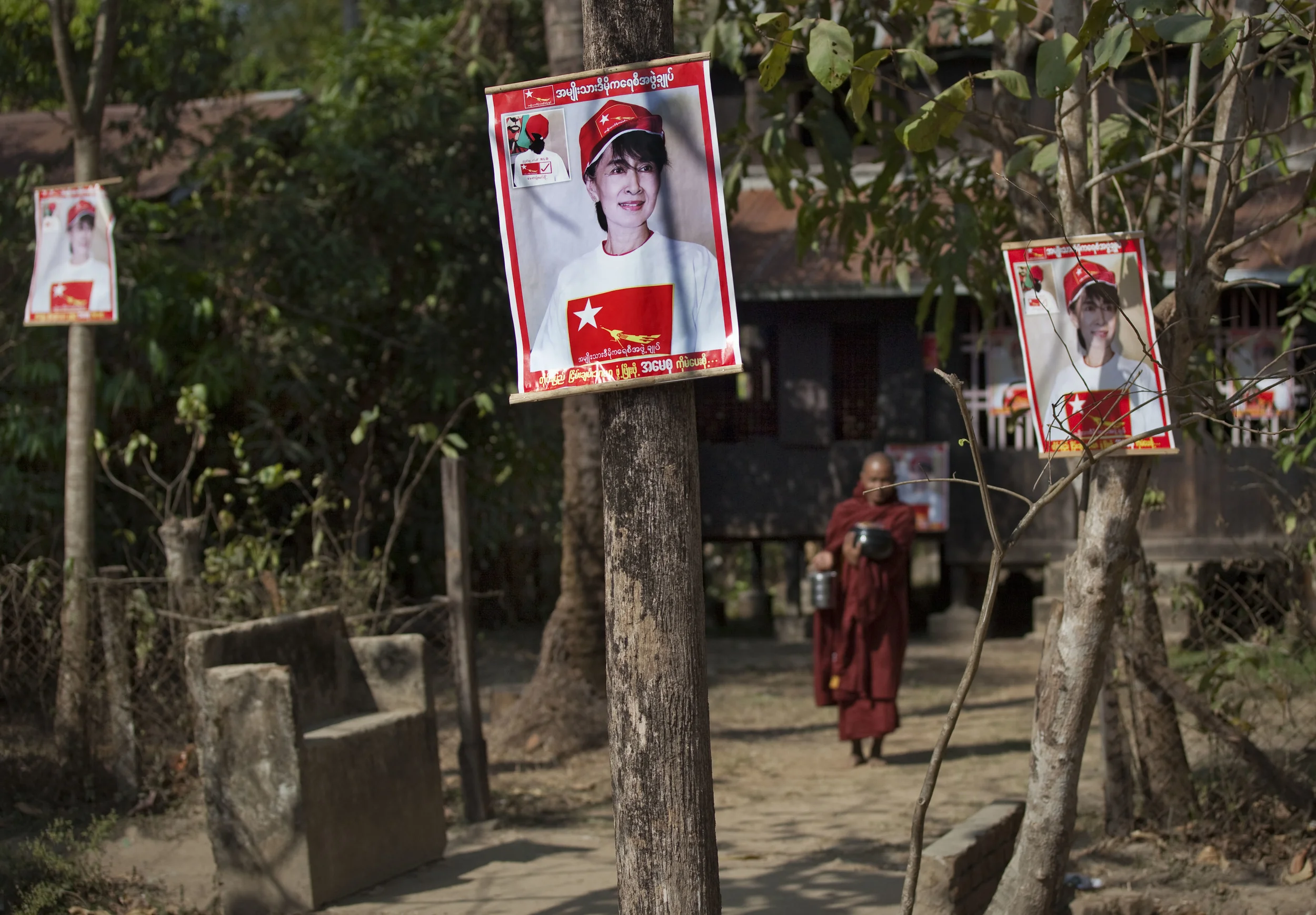  A monk walks past election posters of Aung San Suu Kyi, in Khawhmu, close to Burma's former capital, Rangoon. Days before parliamentary elections. March 2012. 